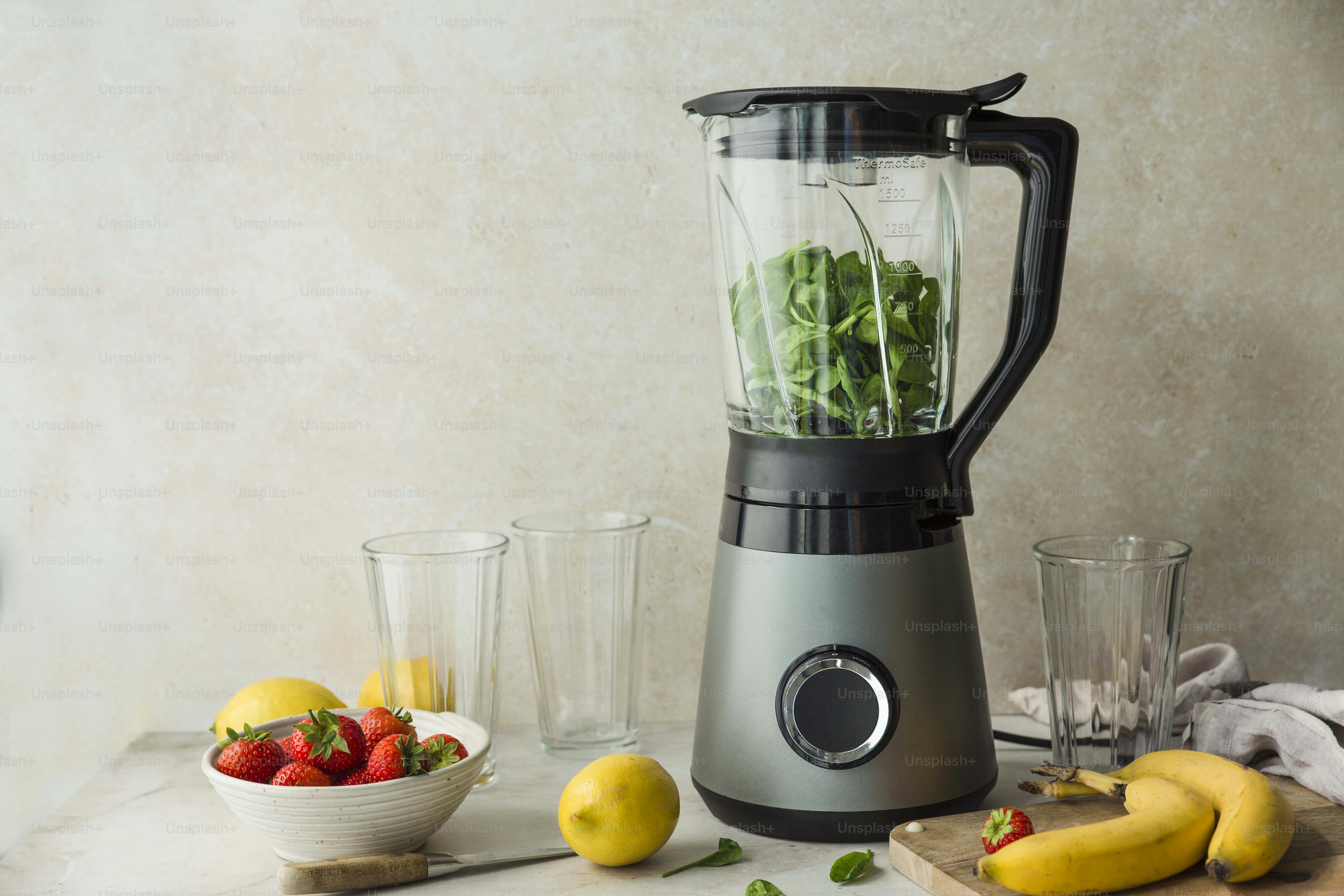 a blender sitting on top of a counter filled with fruit and vegetables