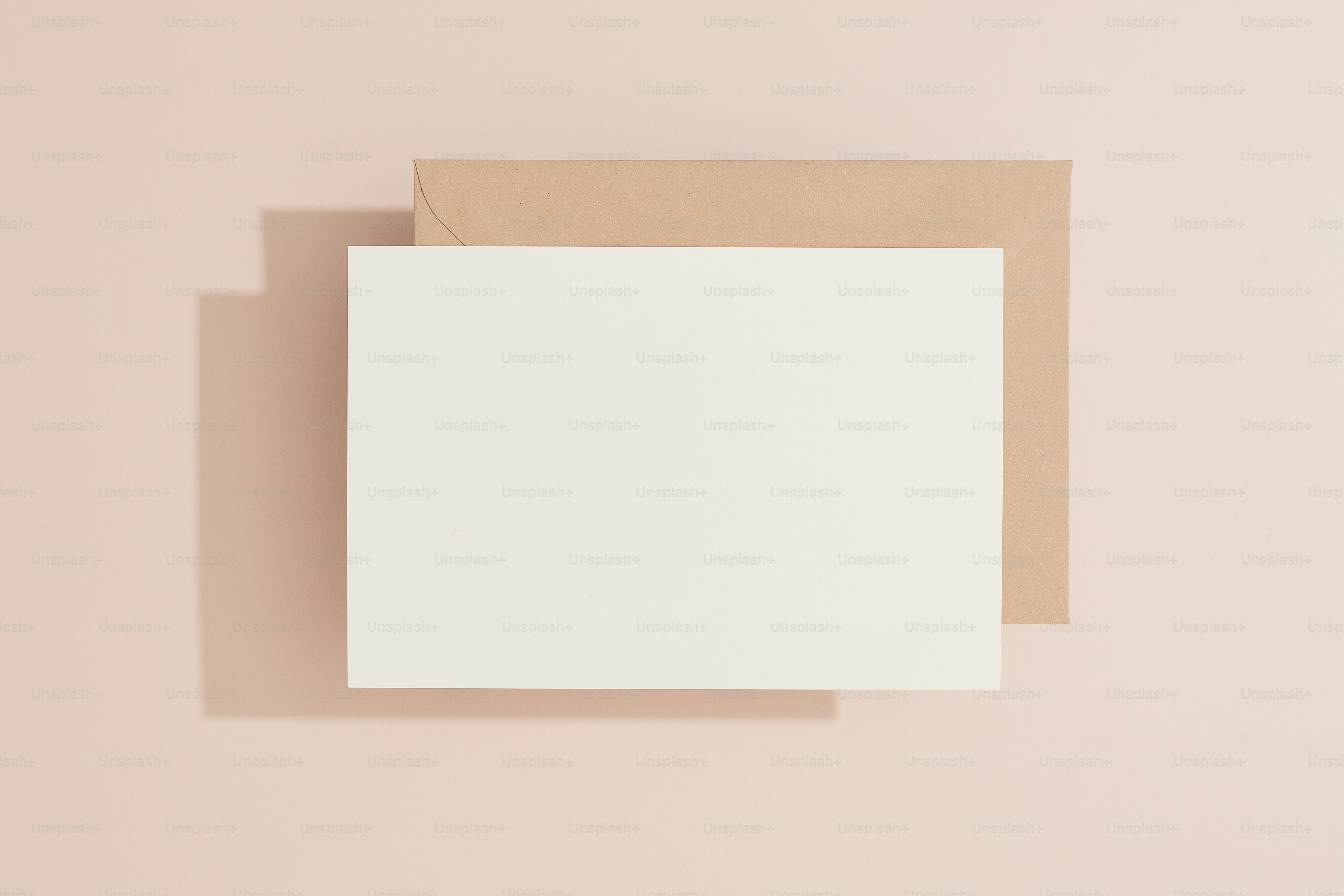 eine leere Karte mit einem braunen Umschlag auf rosa Hintergrund