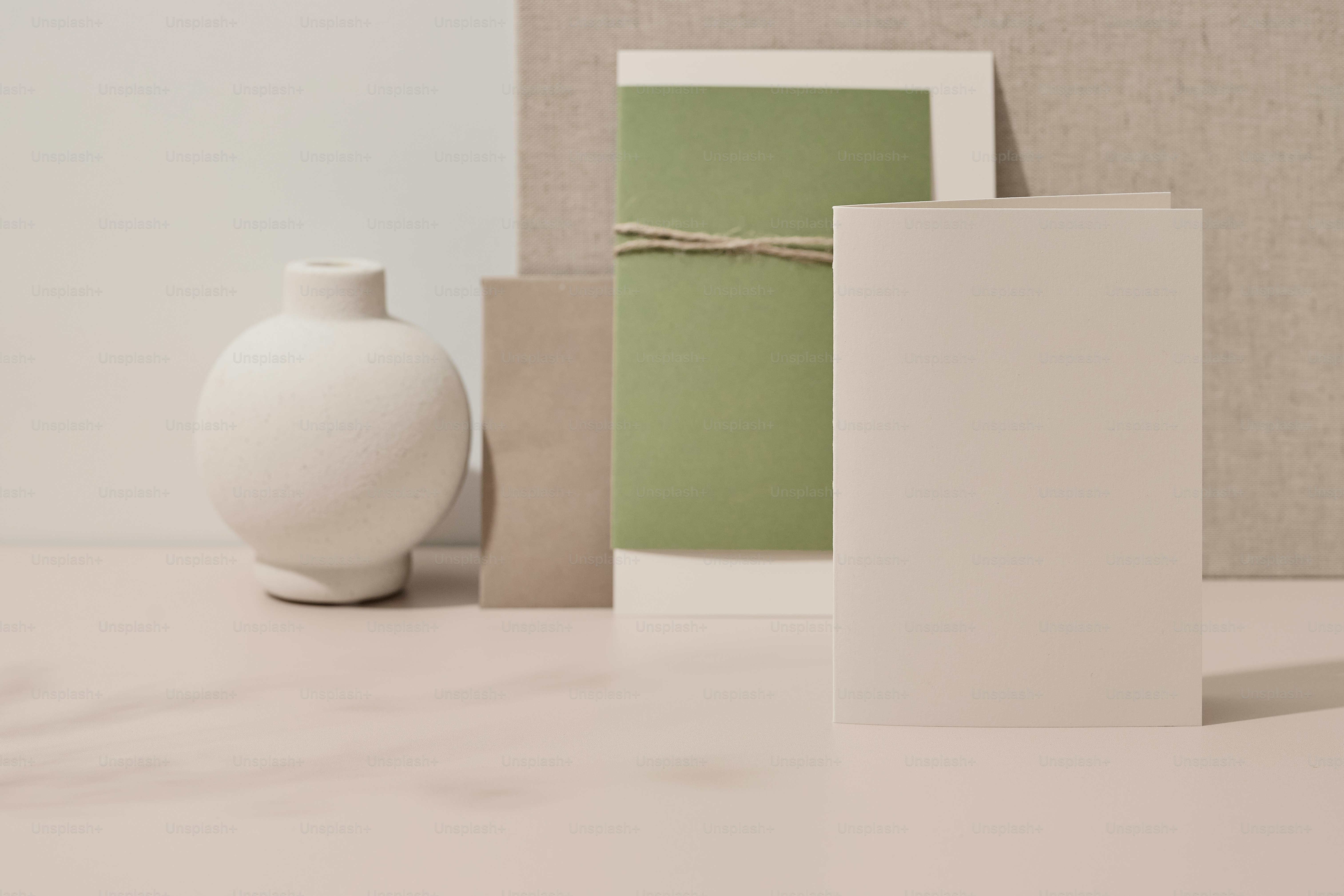 eine weiße Vase neben einer weißen Vase auf einem Tisch