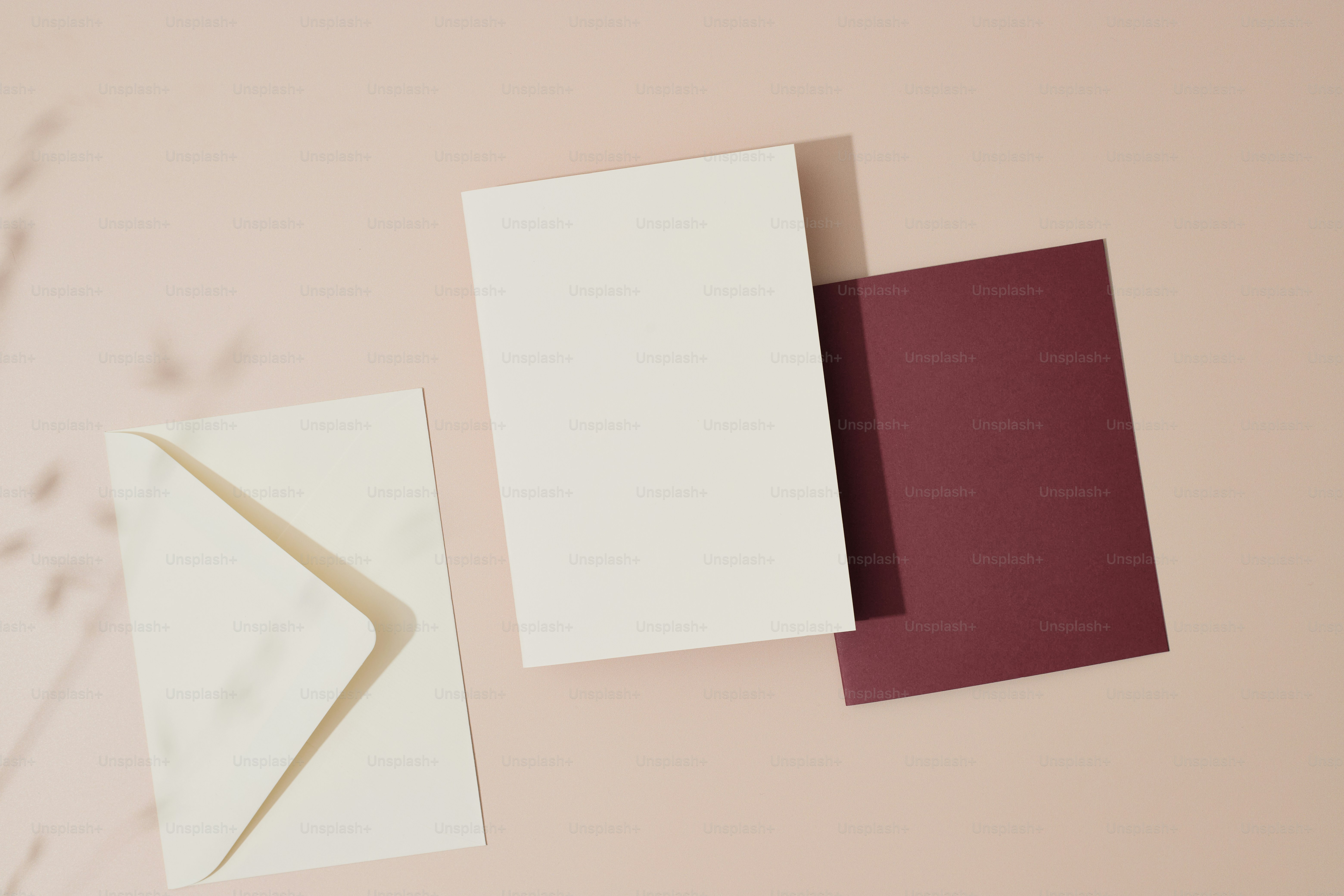 a white envelope and a red envelope on a pink background
