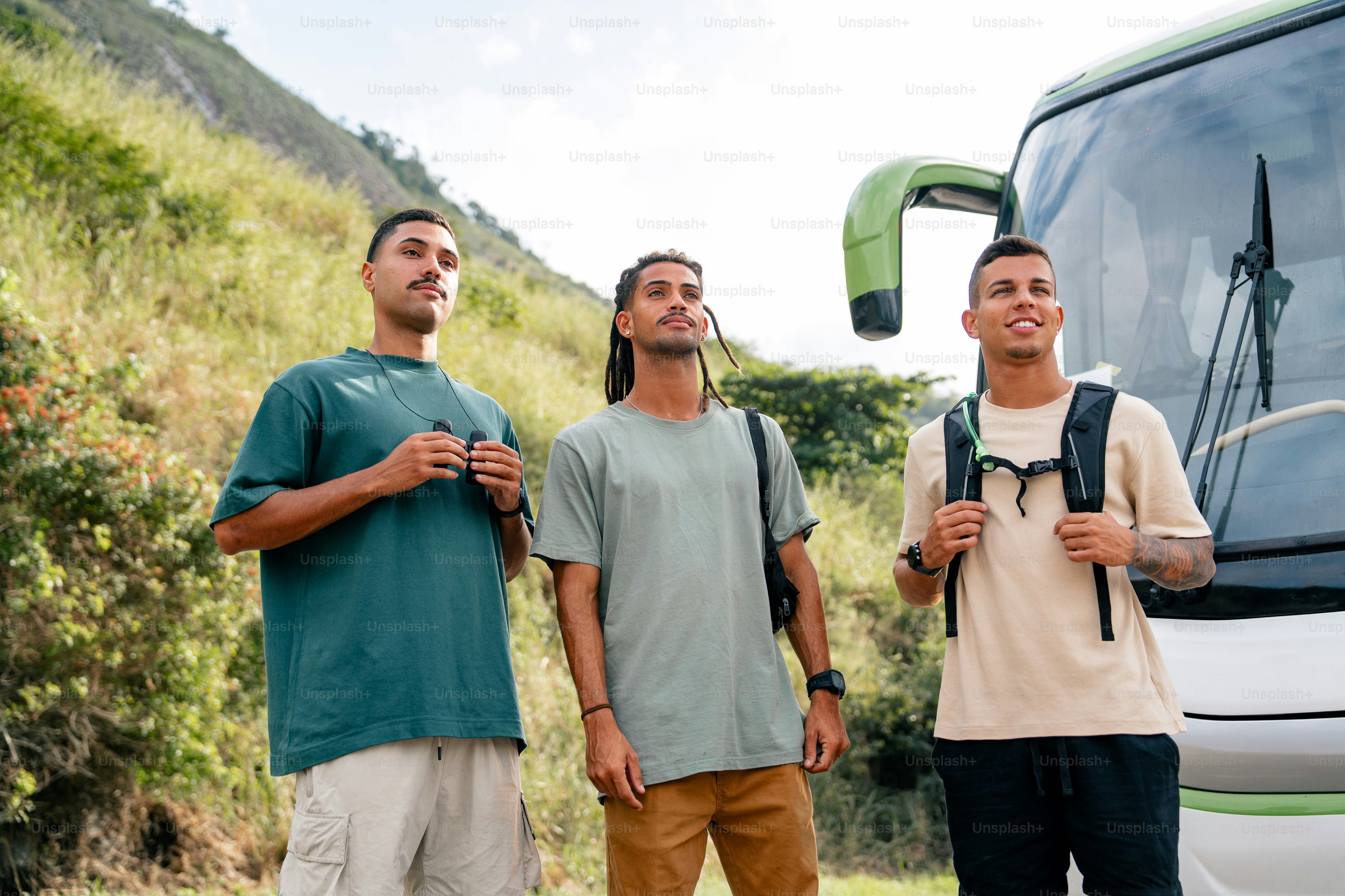 three men standing in front of a bus