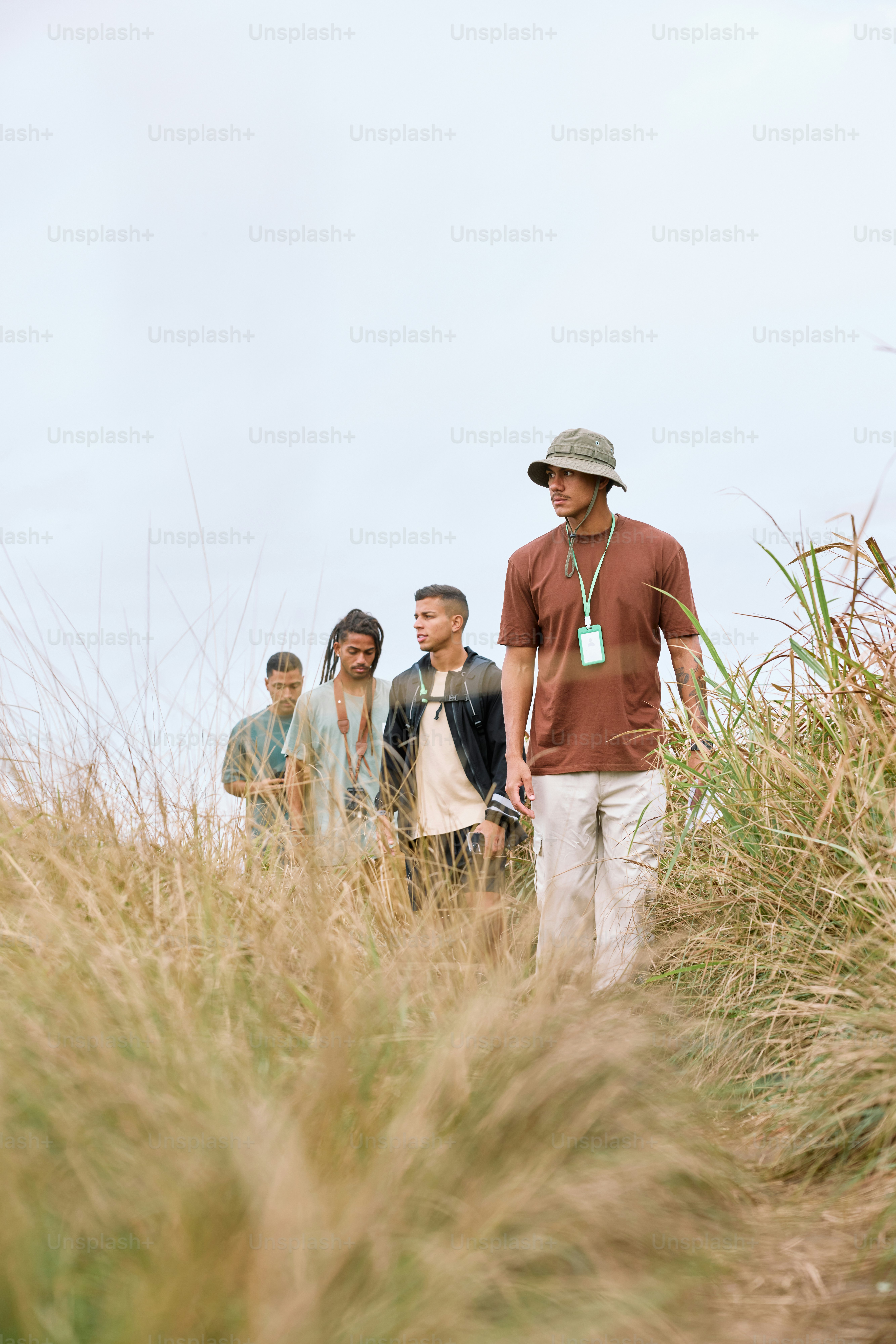 a group of people walking through tall grass