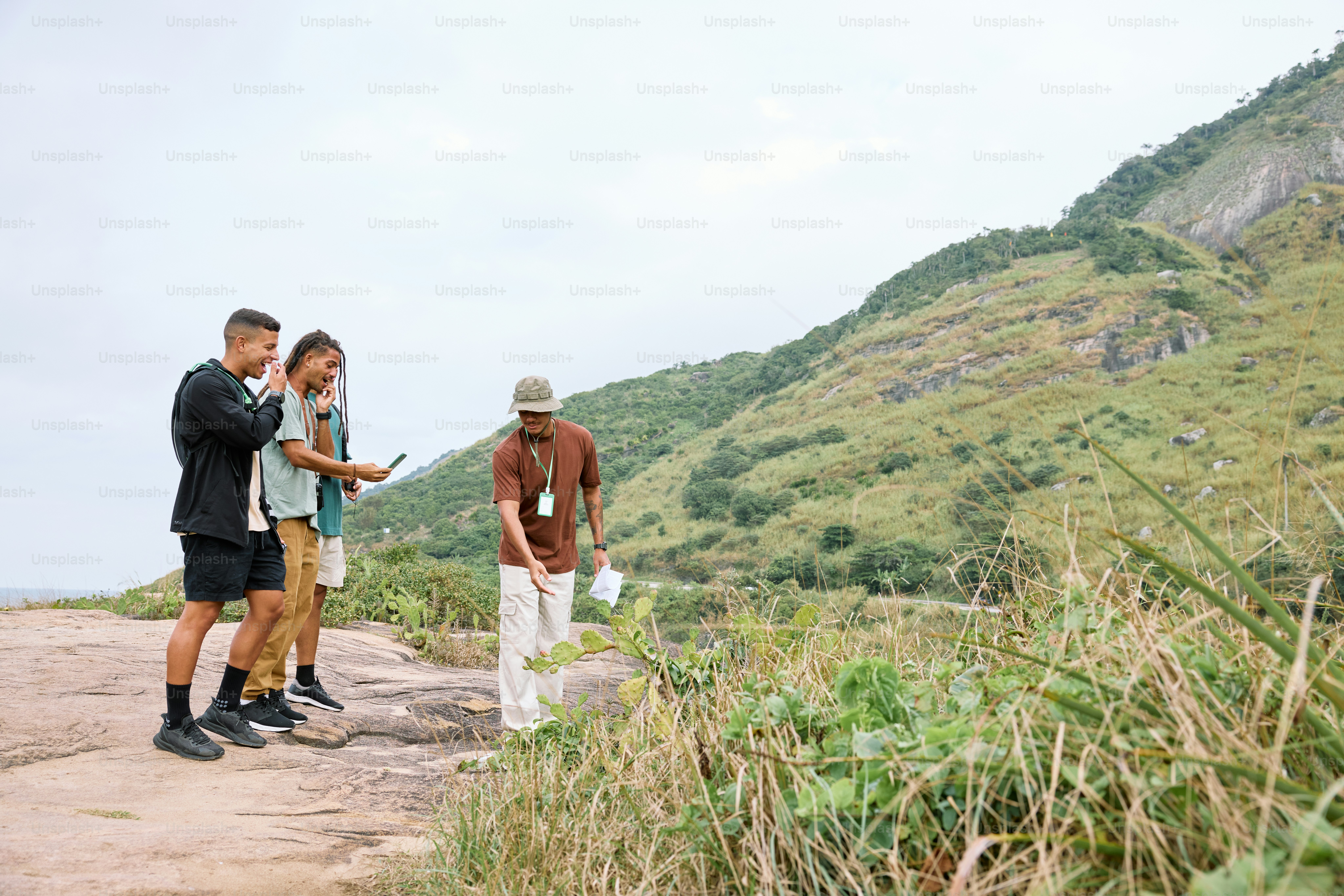 a group of men standing on top of a lush green hillside