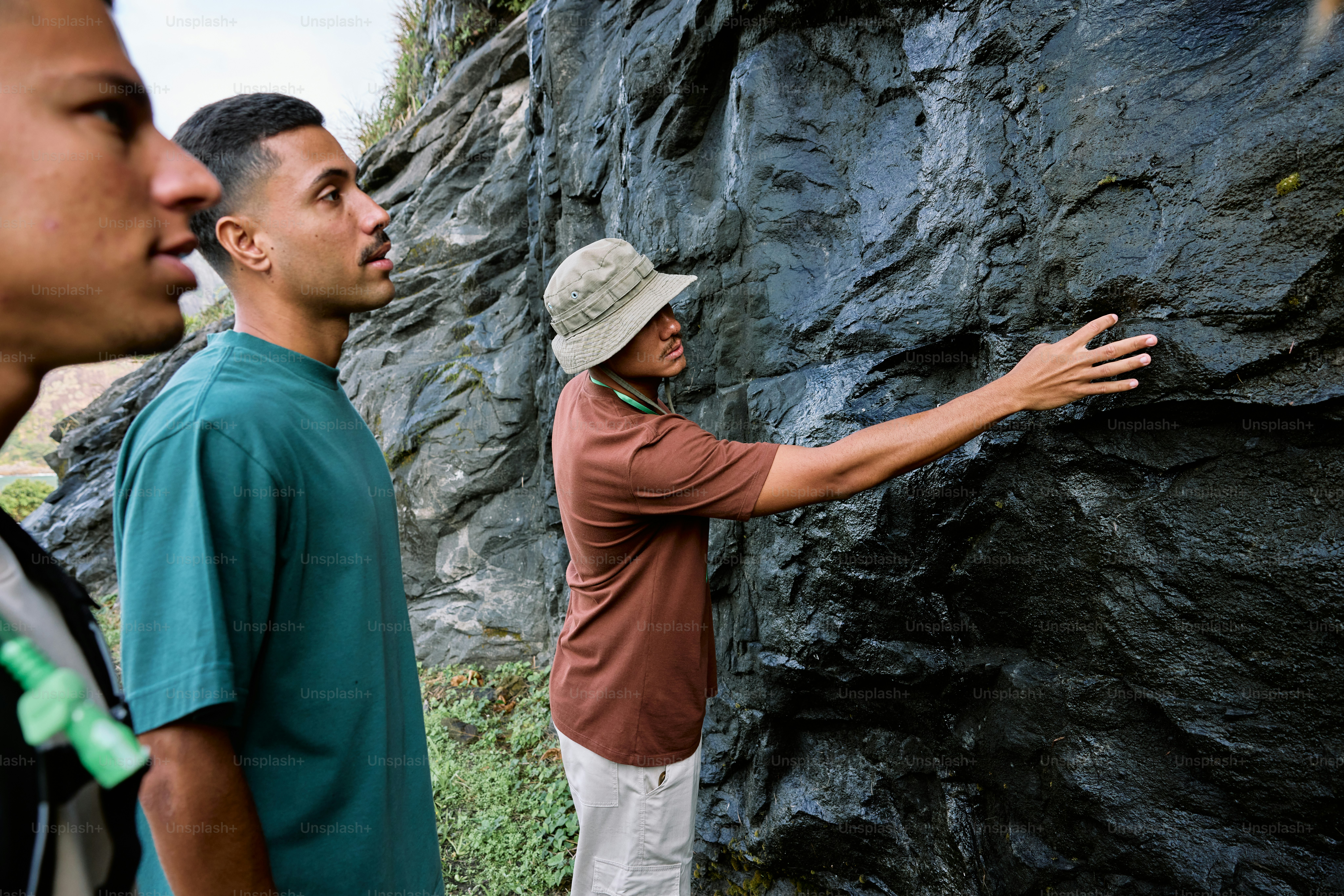 a group of men standing next to each other near a mountain