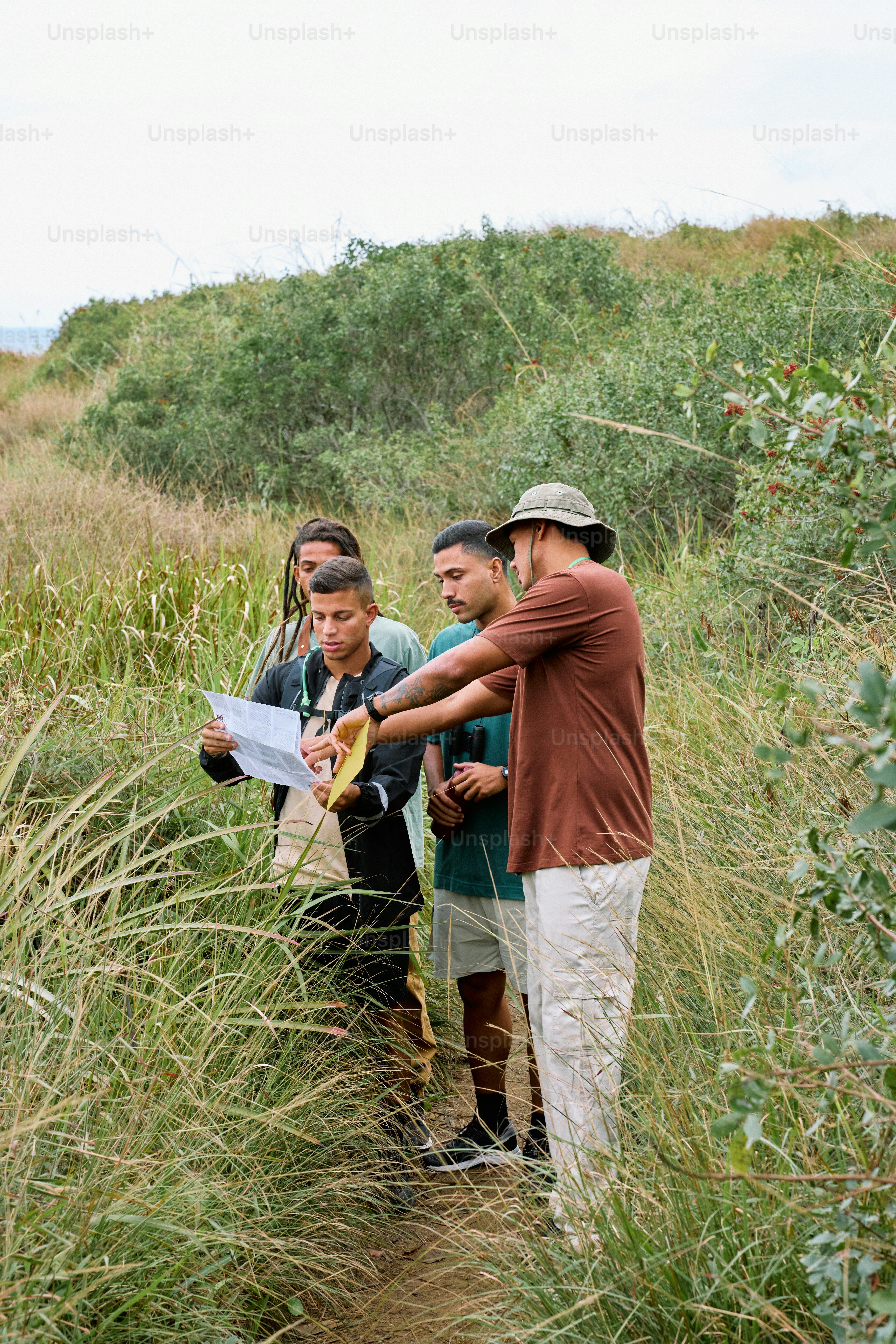a group of people standing in tall grass