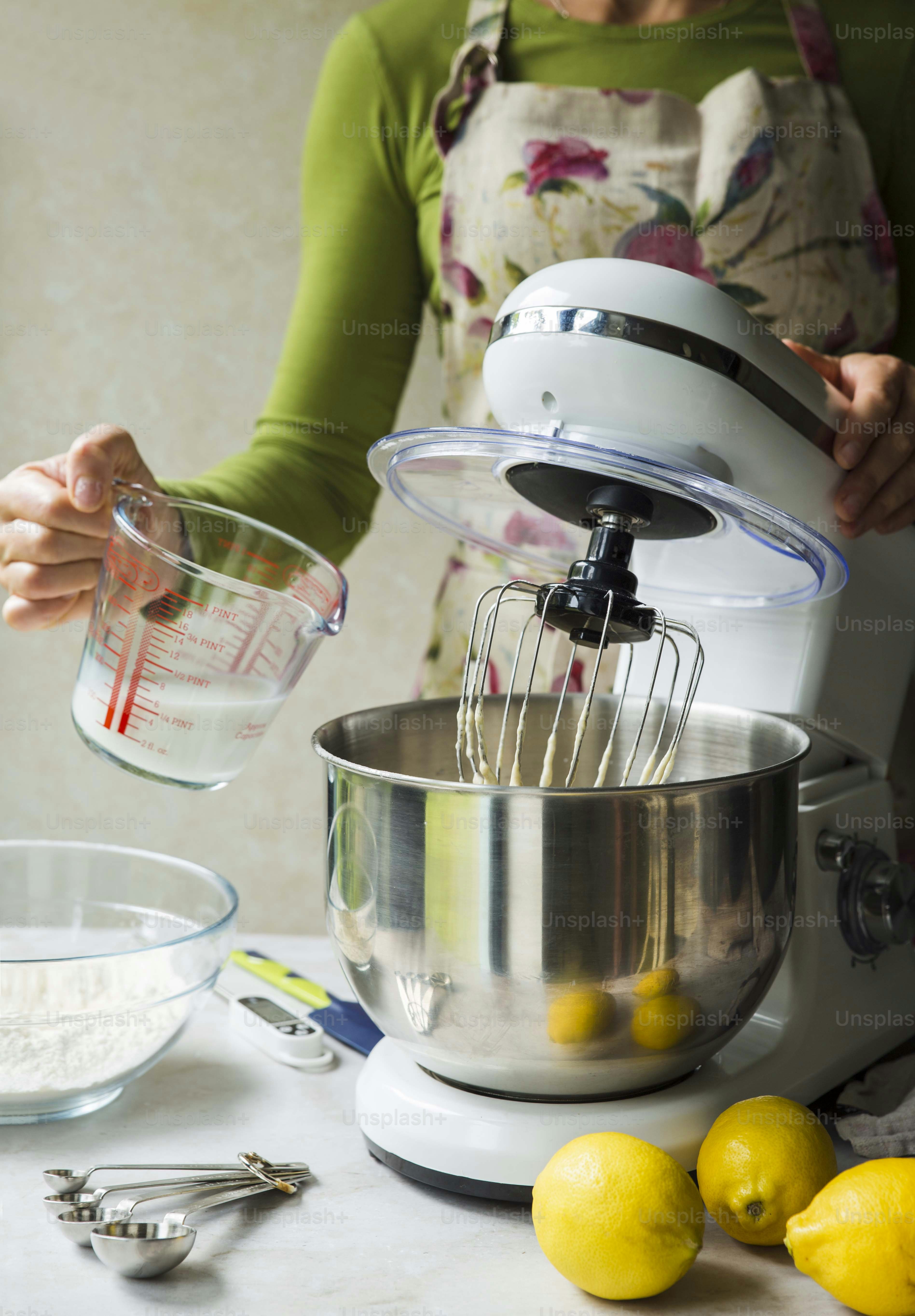 A woman is mixing ingredients in a mixer