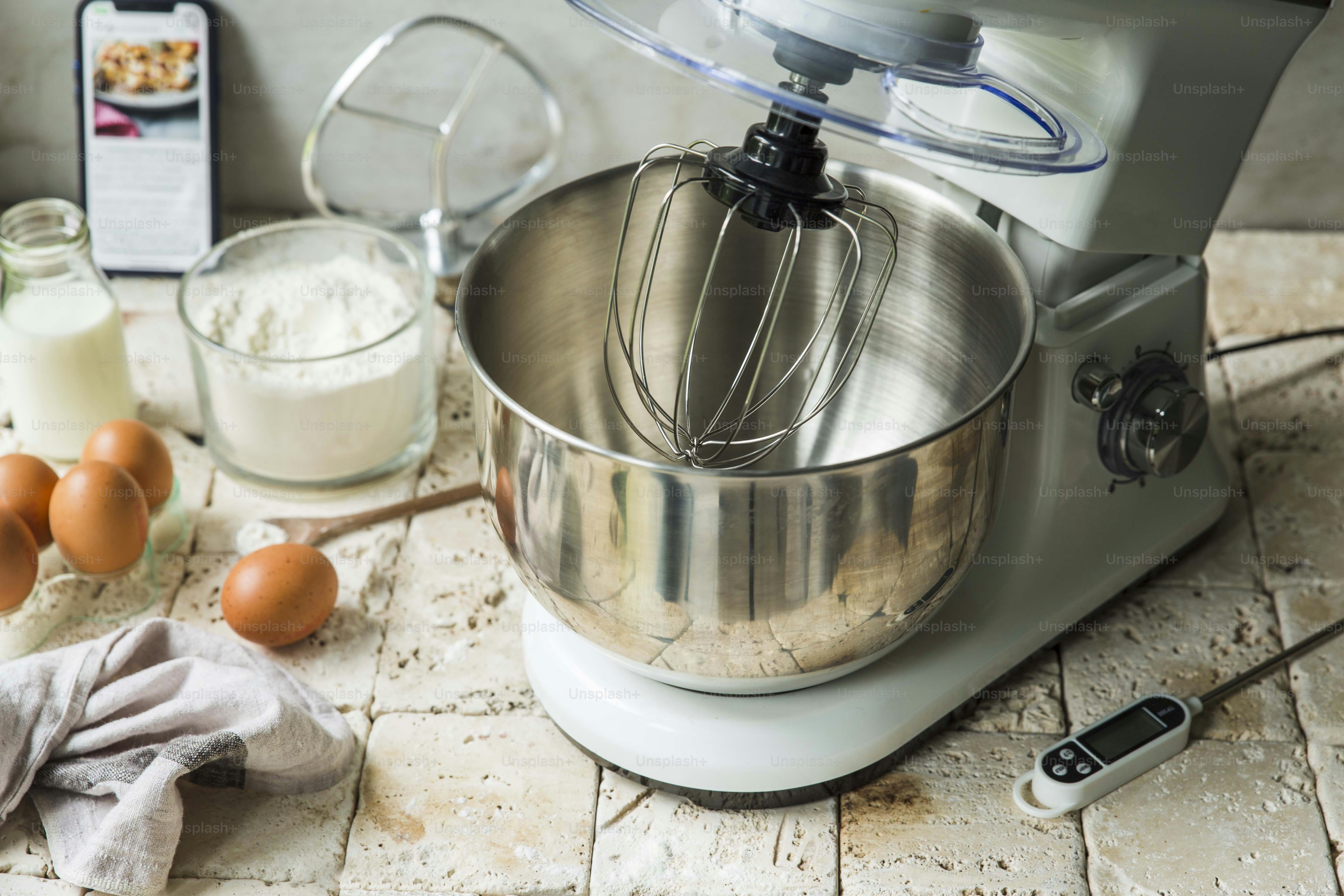 a mixer sitting on top of a counter next to eggs
