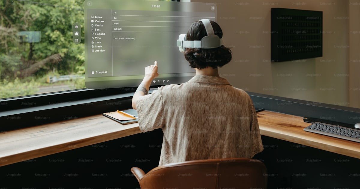 A woman sitting at a desk in front of a computer monitor photo – Mixed ...