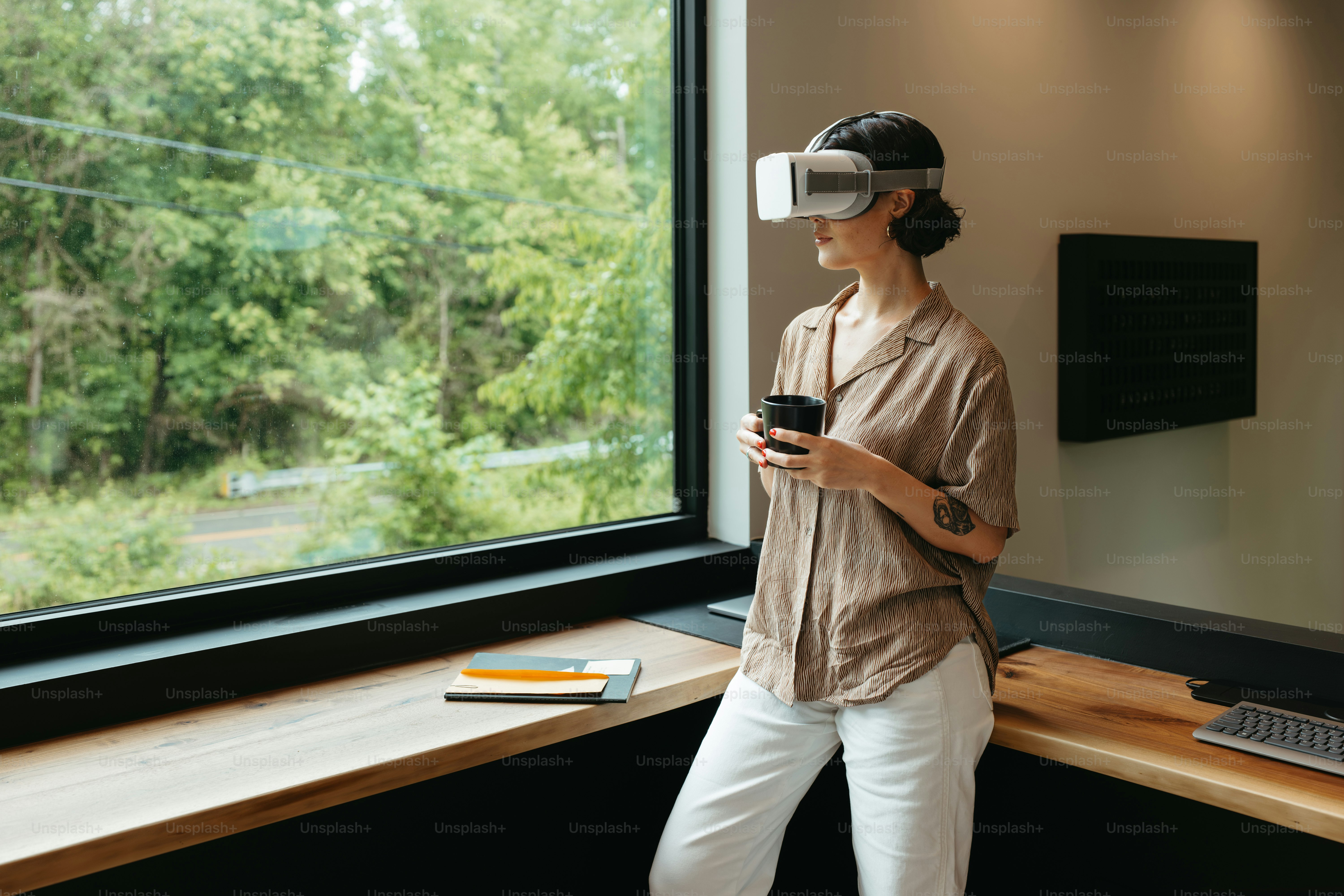 Una mujer de pie frente a una ventana con un casco virtual