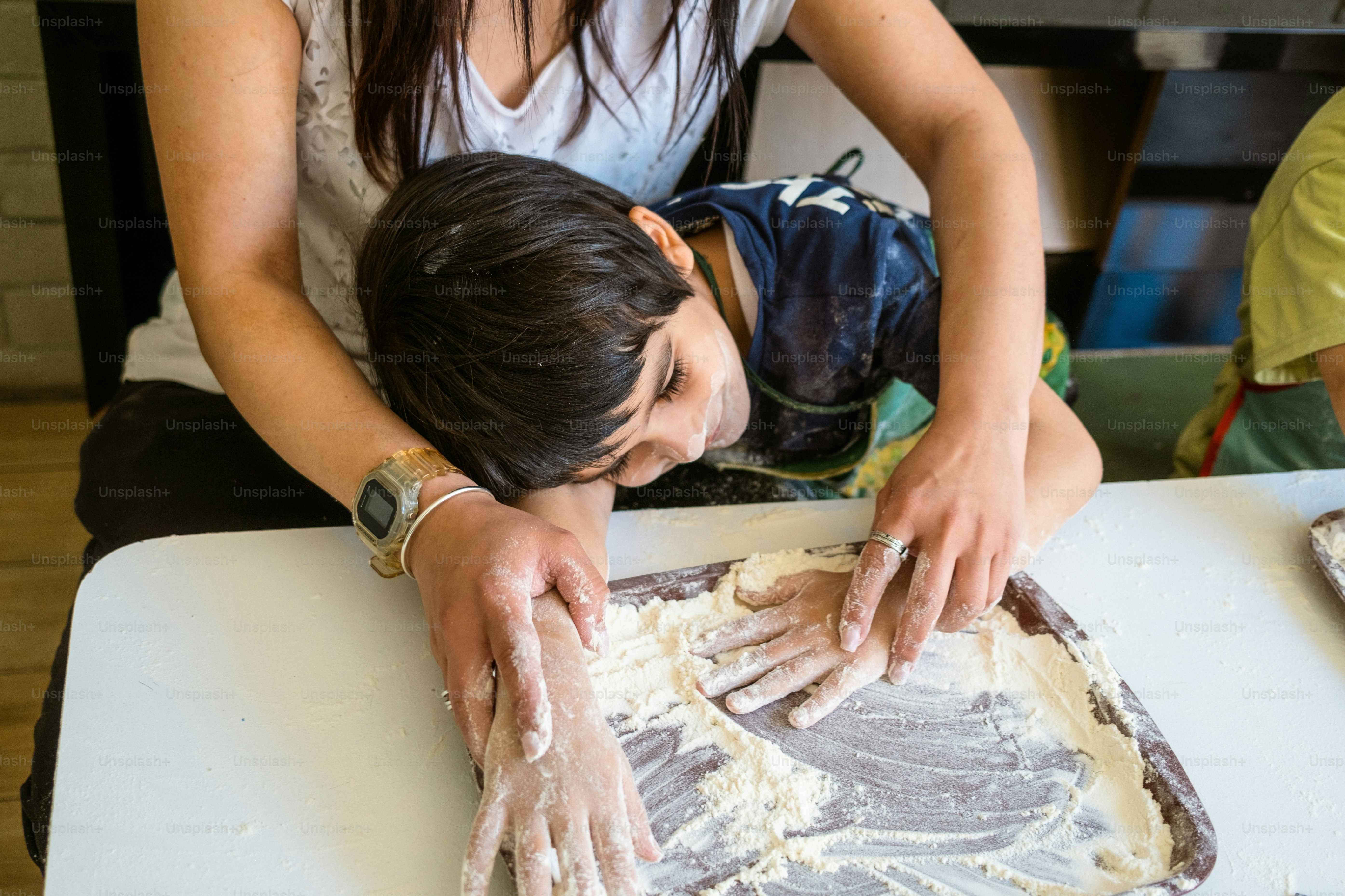 a woman and a child are making food
