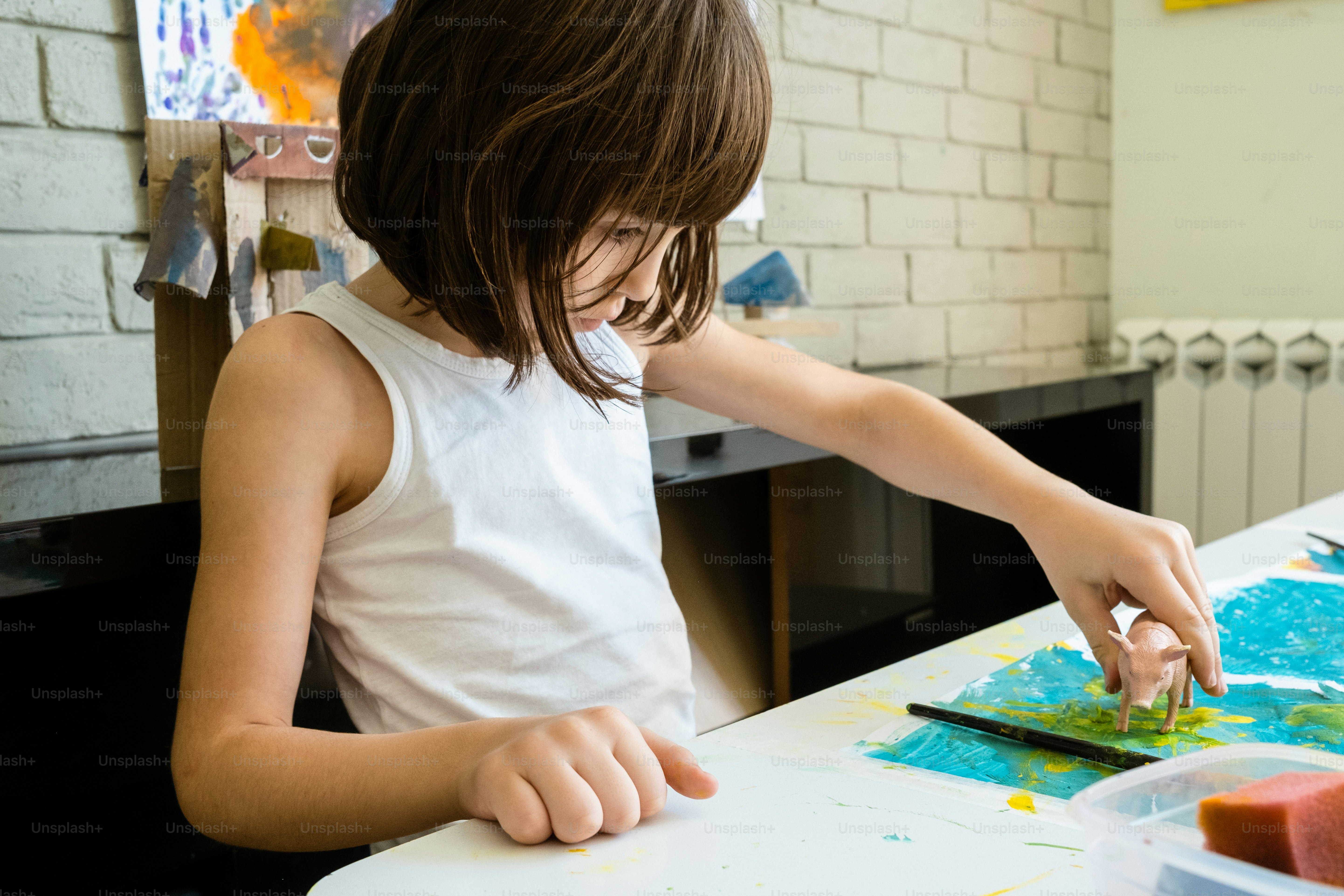 uma menina pintando em um pedaço de papel
