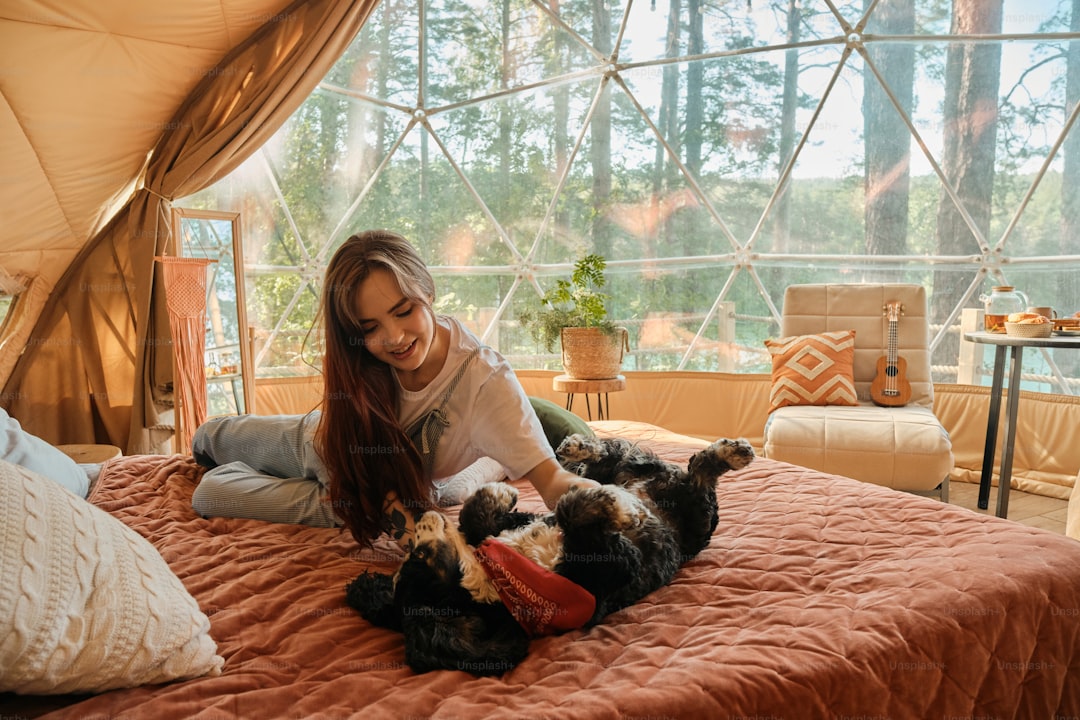 a woman laying on a bed with two dogs