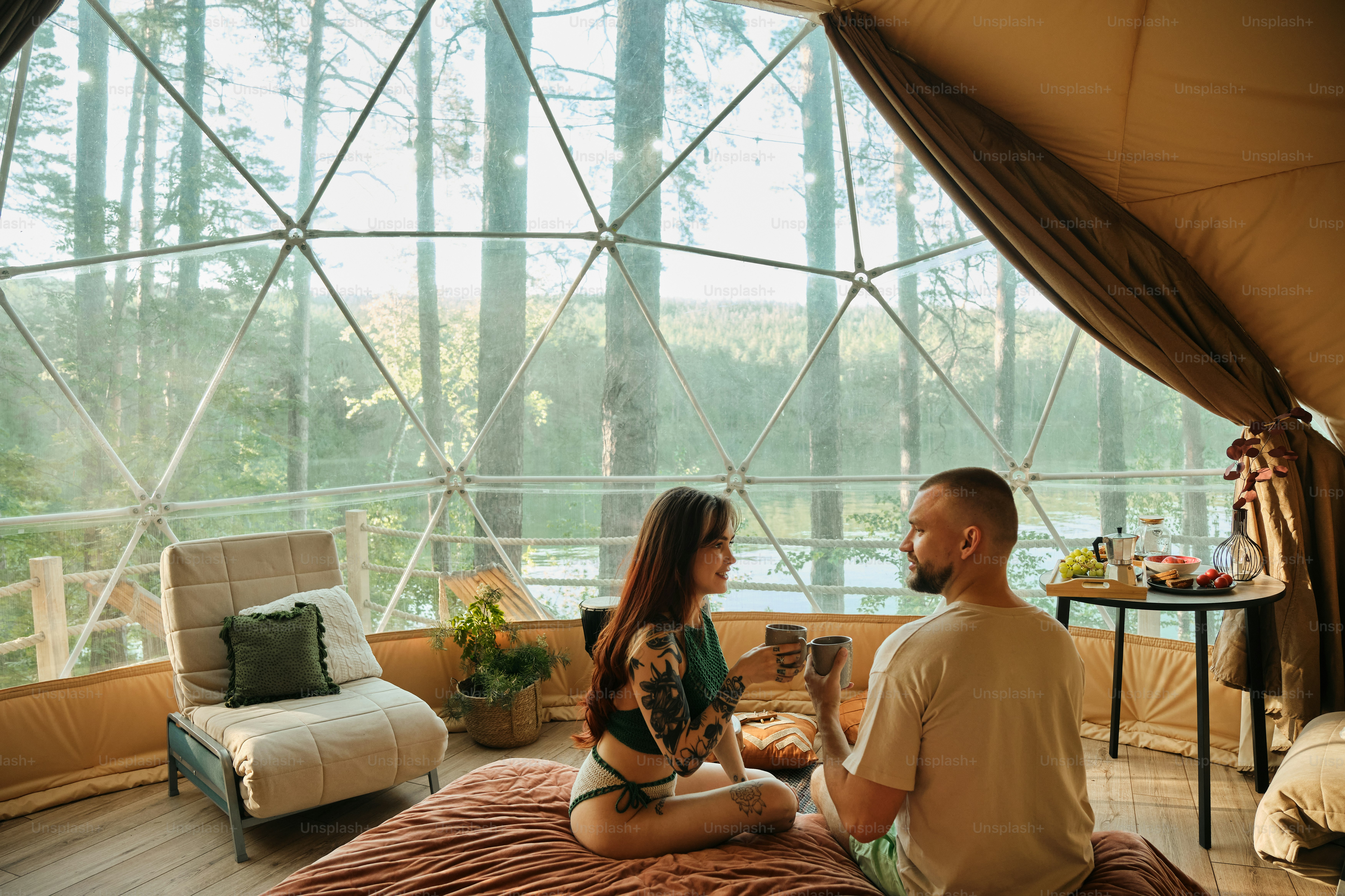 un homme et une femme assis sur un lit dans une tente