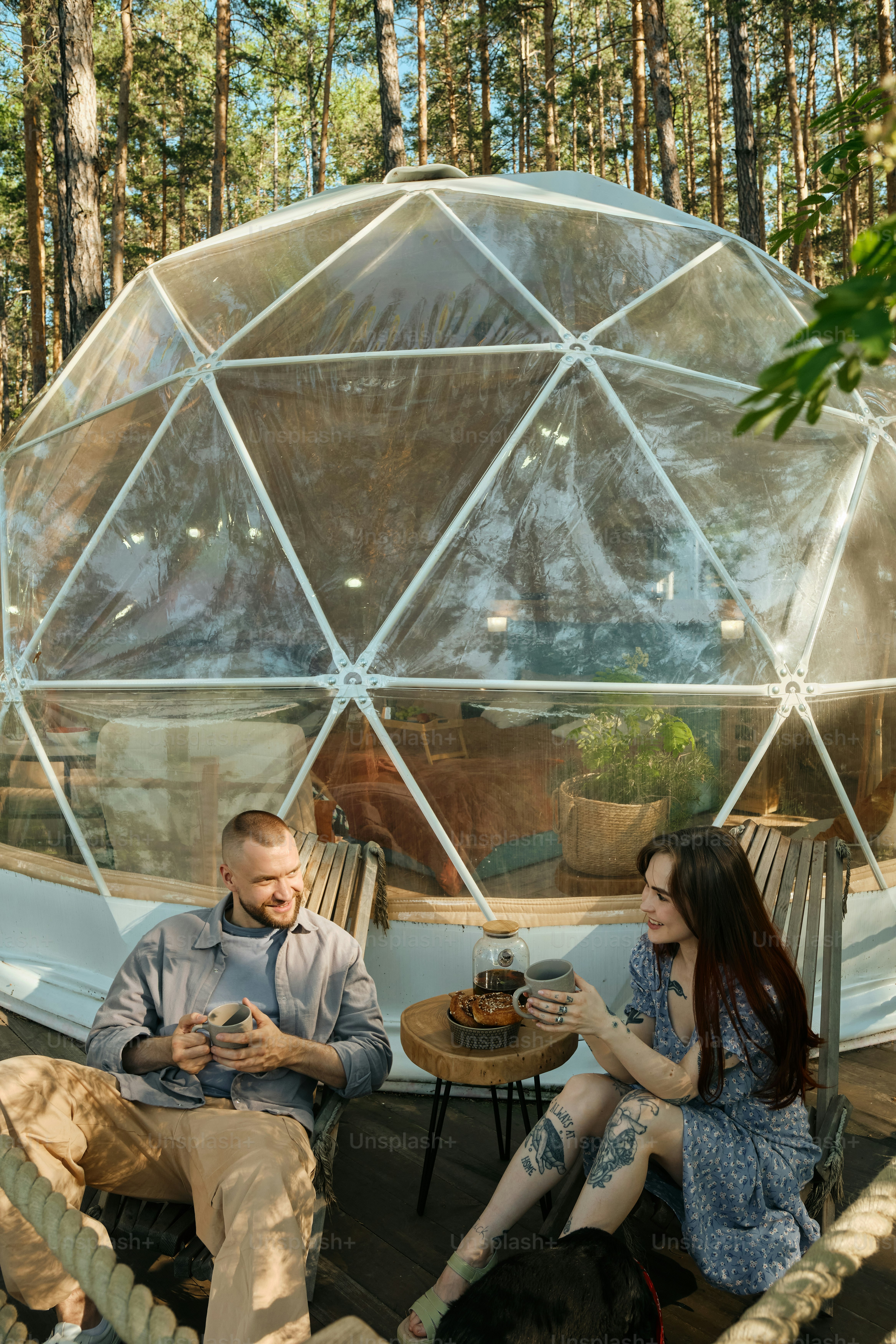 Couple relaxing on the terrace of an igloo-sphere glamping house