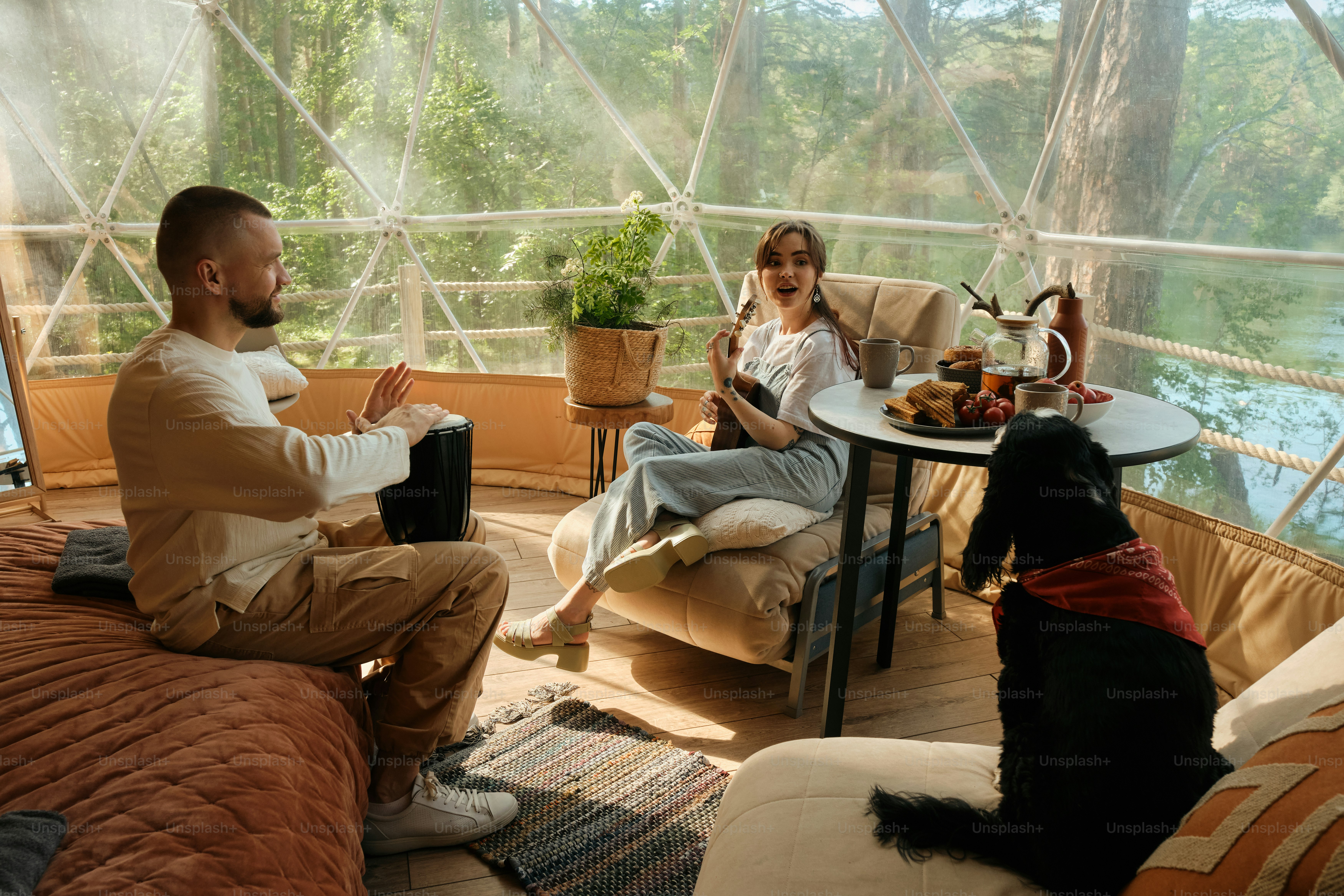 un homme et une femme assis dans une tente avec un chien