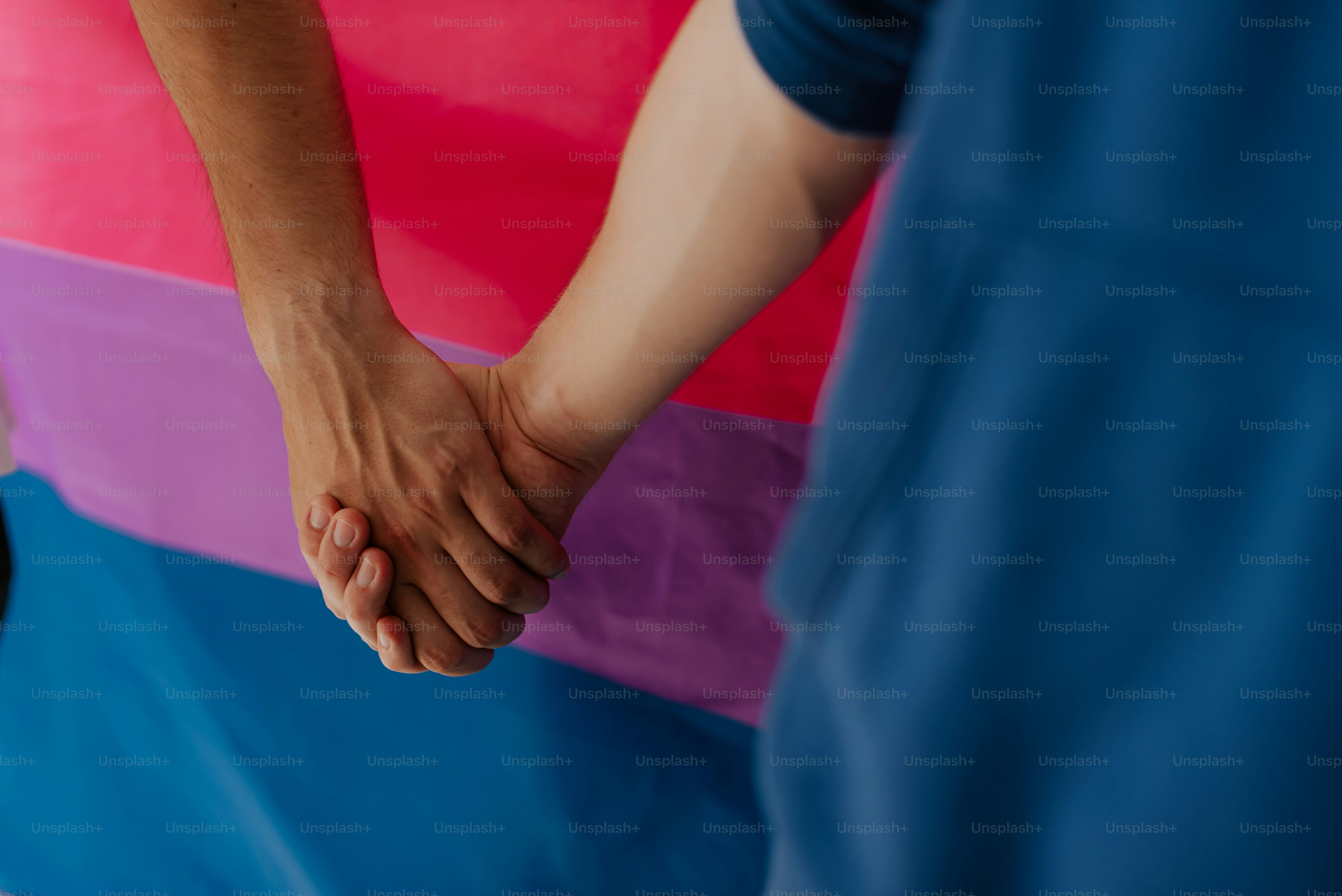 A close up of two people holding hands photo – Bisexual flag Image on ...