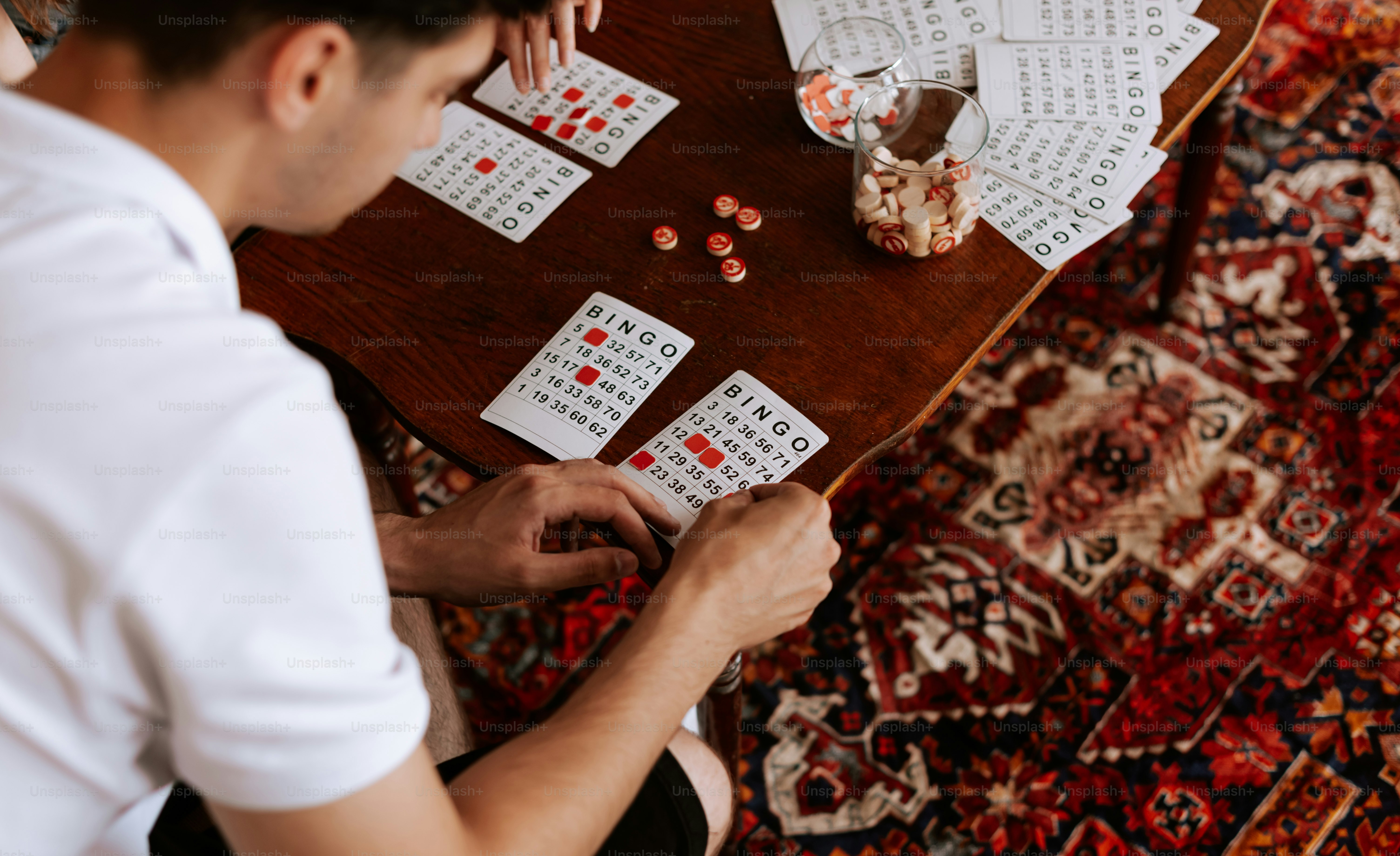 a man sitting at a table playing a game of dominos