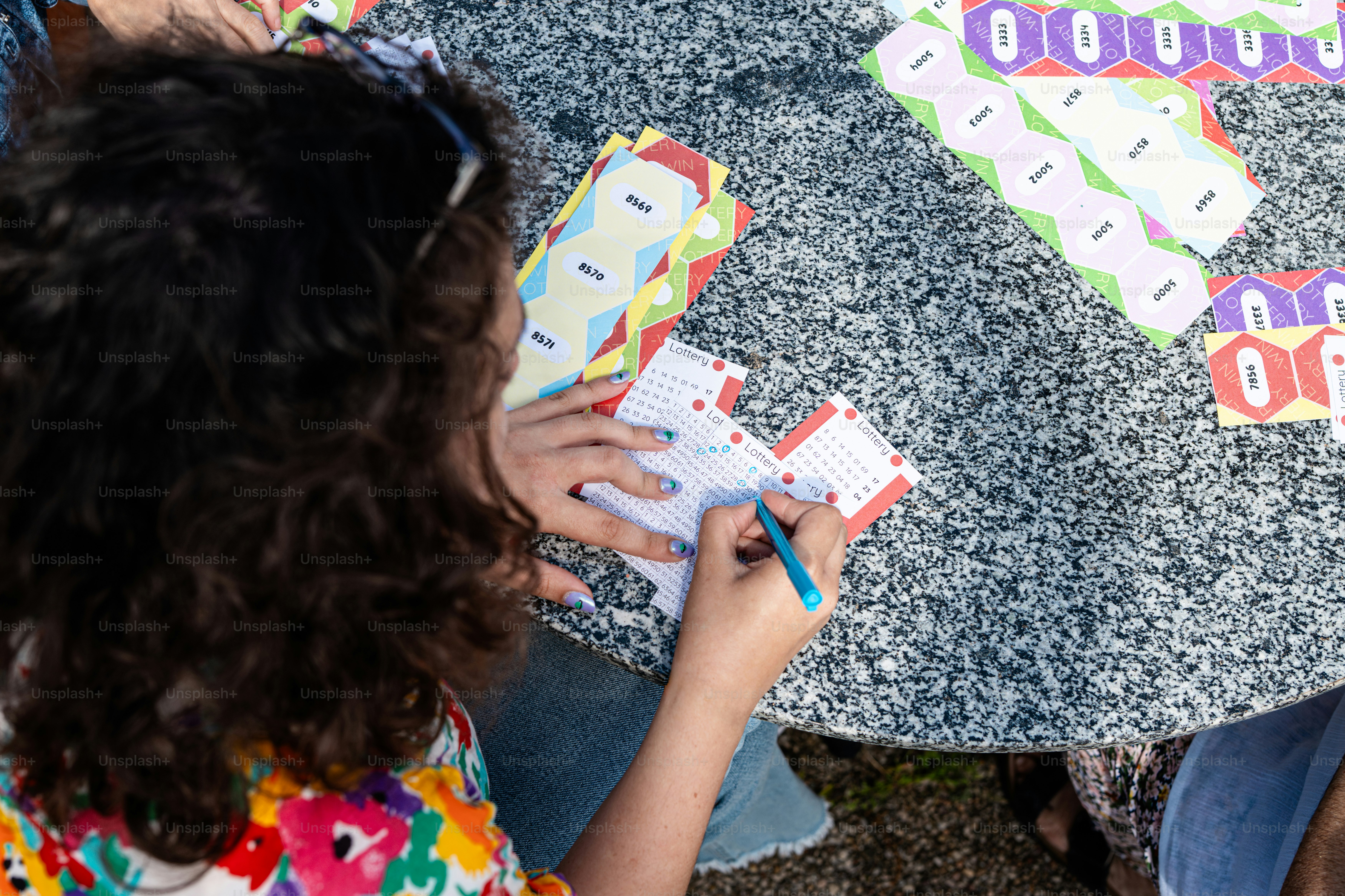 a little girl sitting at a table playing with a game