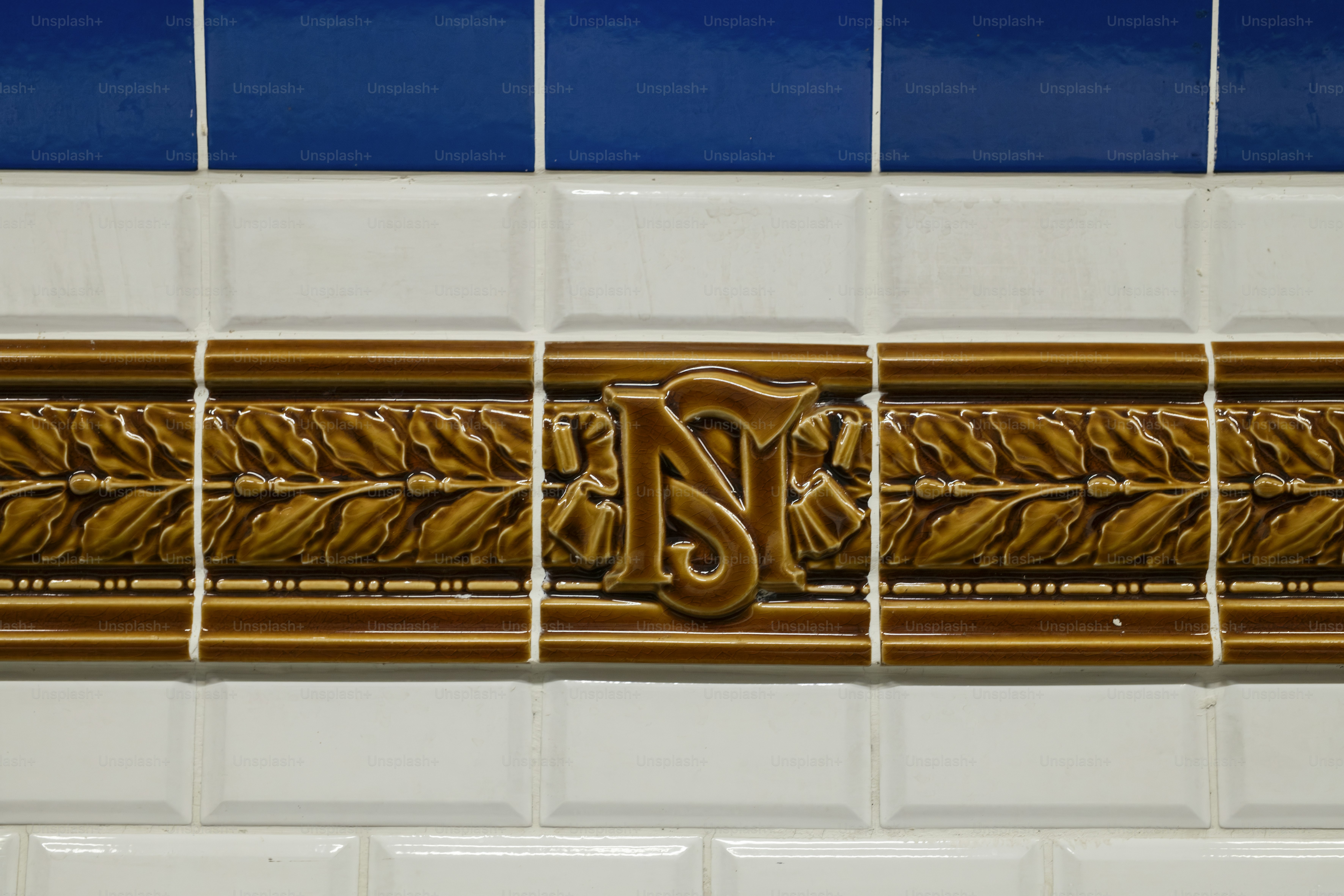 a close up of a tile wall with a decorative design