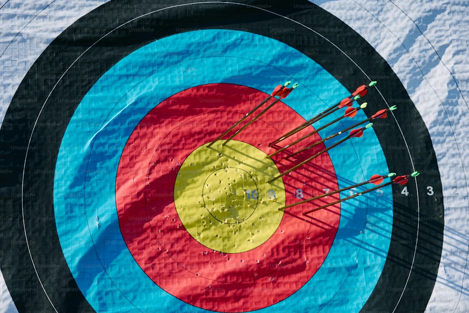 Close-up of an archery target with arrows clustered near the center