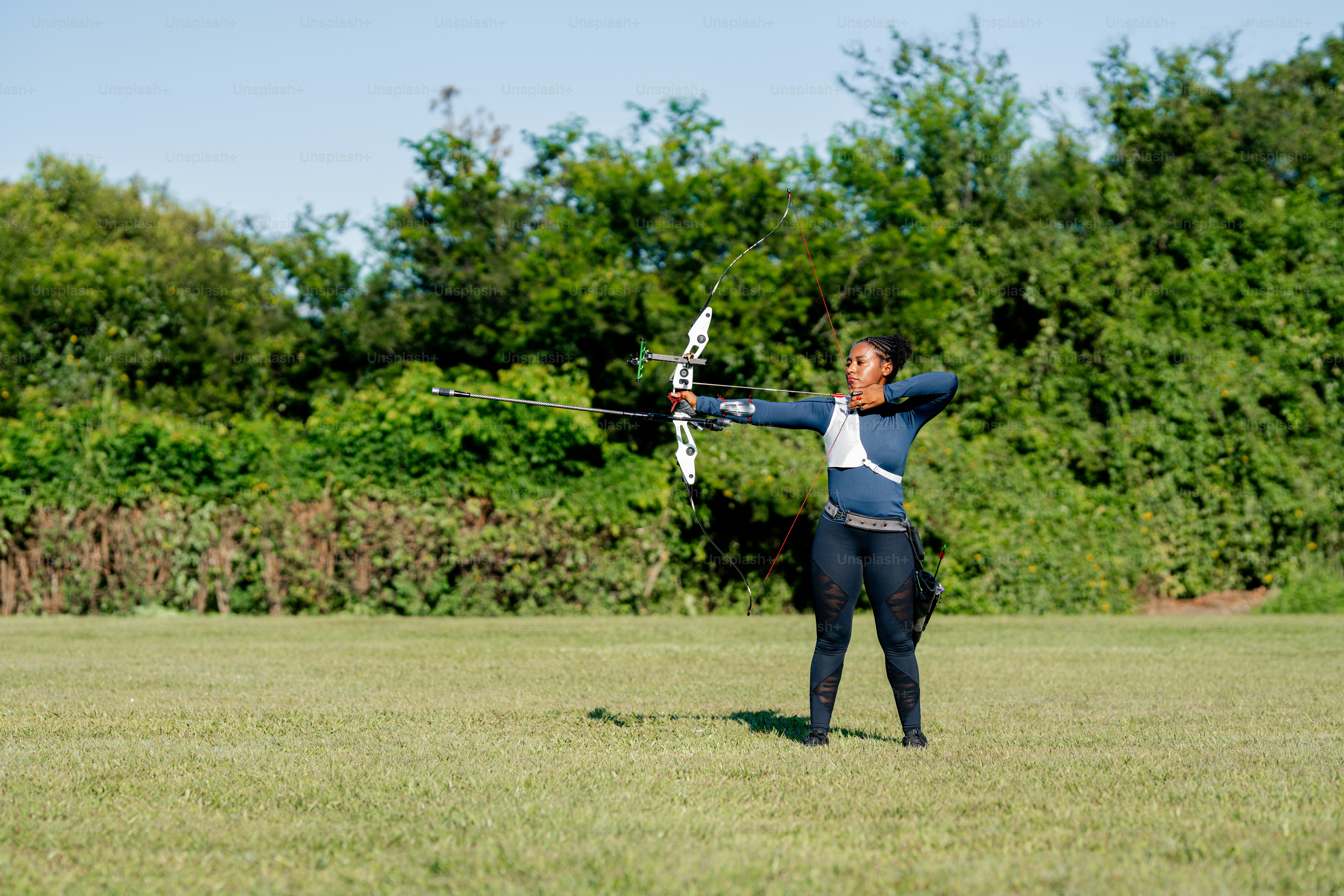 활과 화살을 들고 들판에 있는 남자