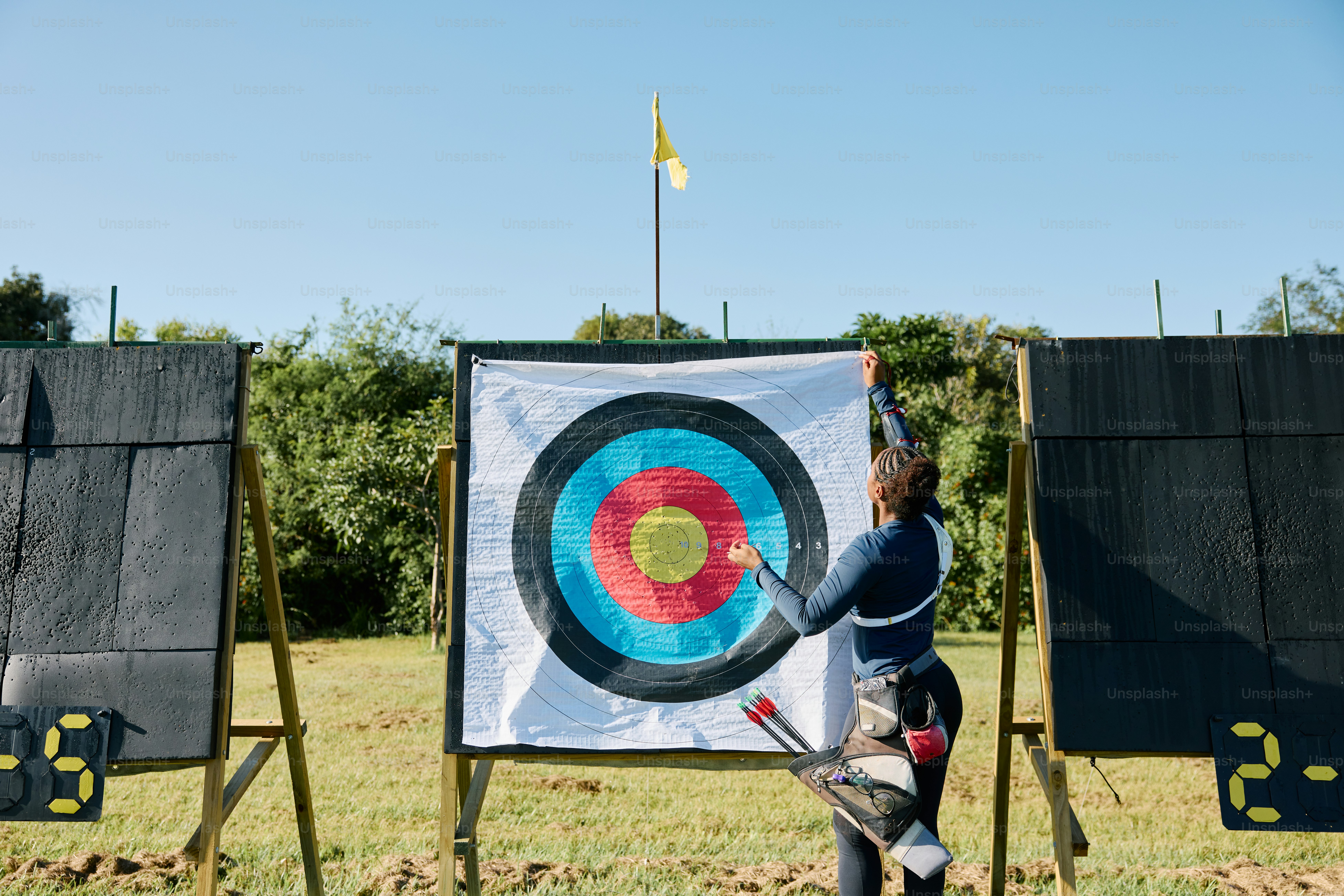 과녁 앞에서 활과 화살을 들고 있는 여성