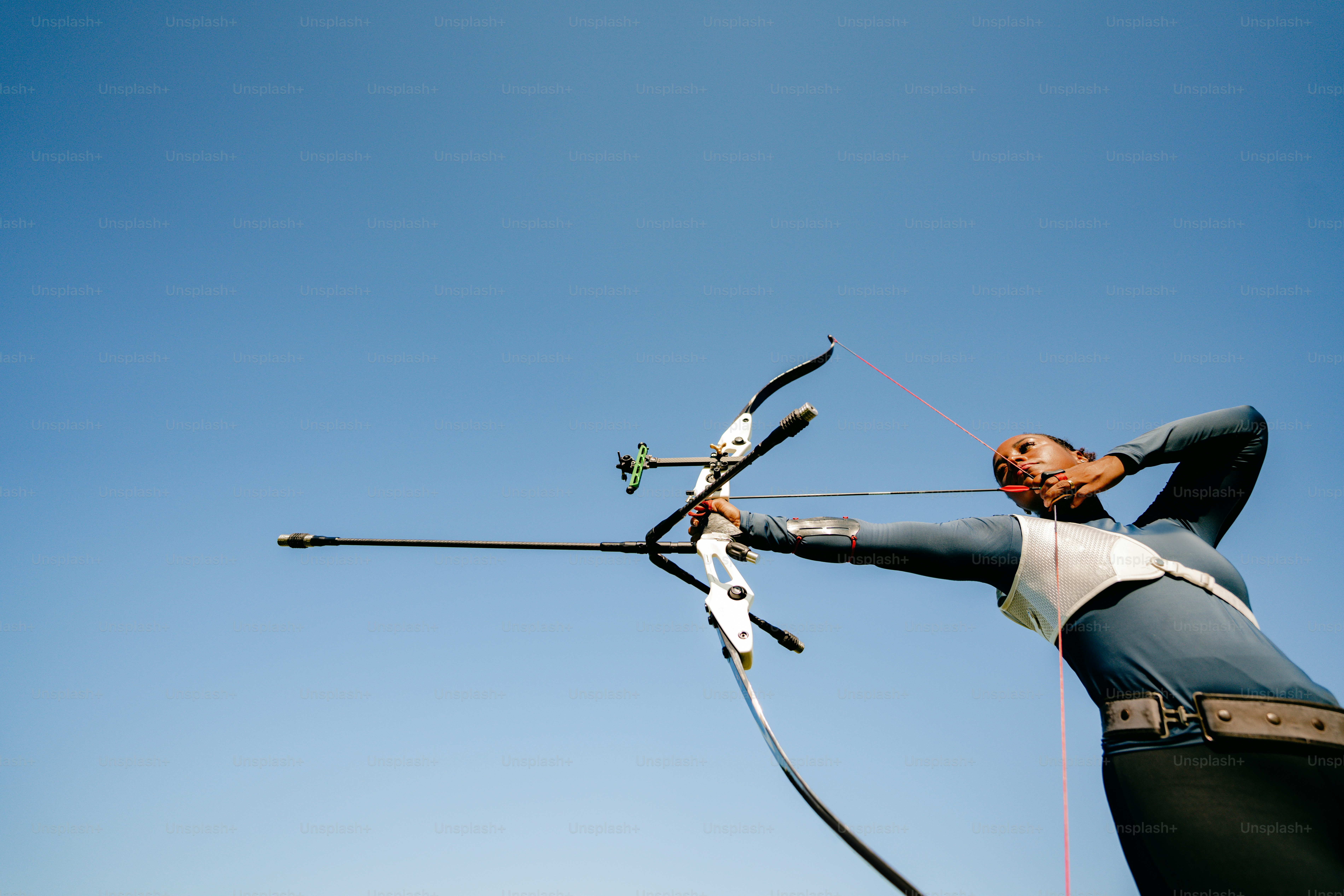 a woman holding a pair of skis while standing next to a pole