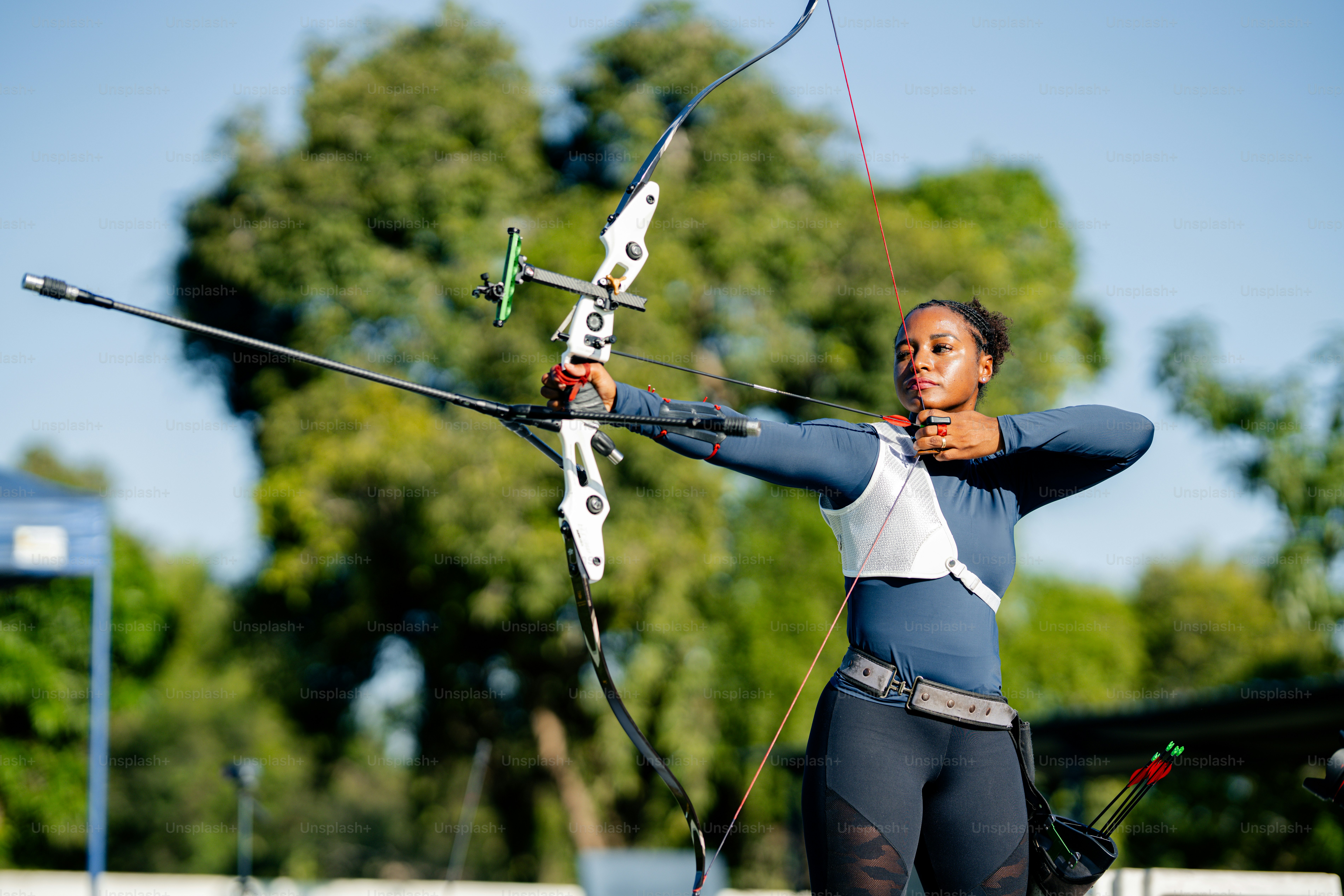 한 여성이 활을 들고 조준하고 있습니다