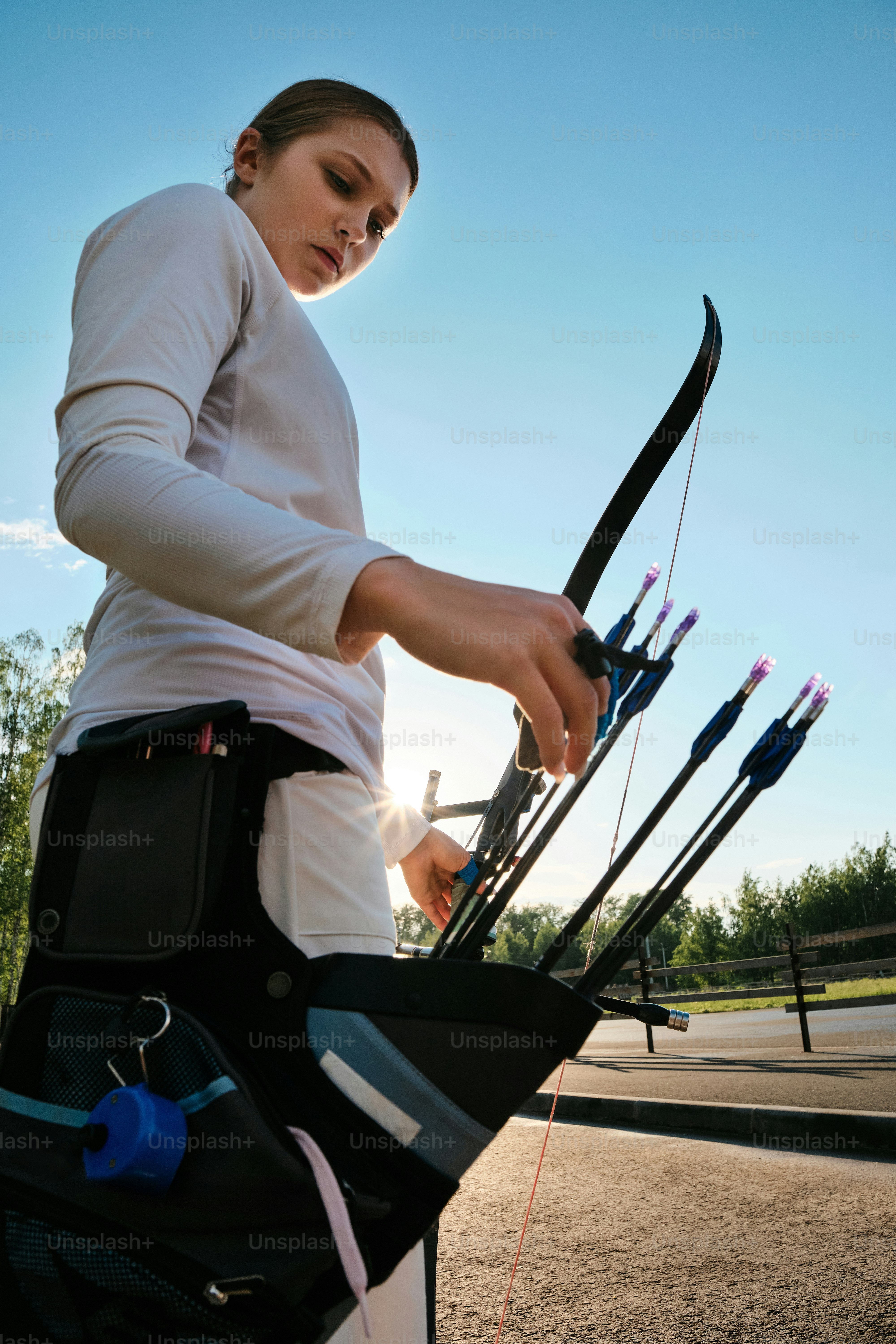 a woman is holding a bow and arrows