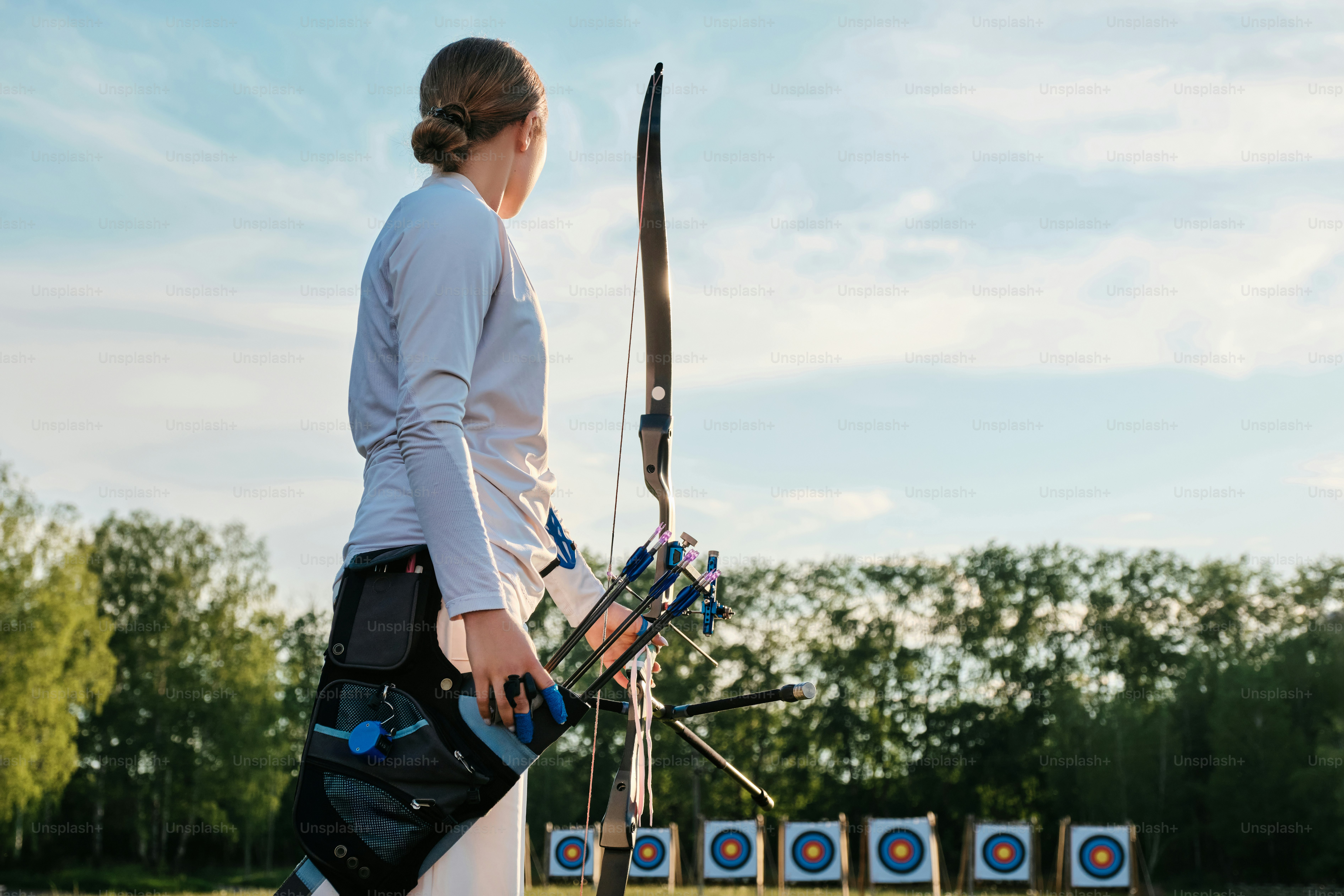 a woman is holding a bow and arrow