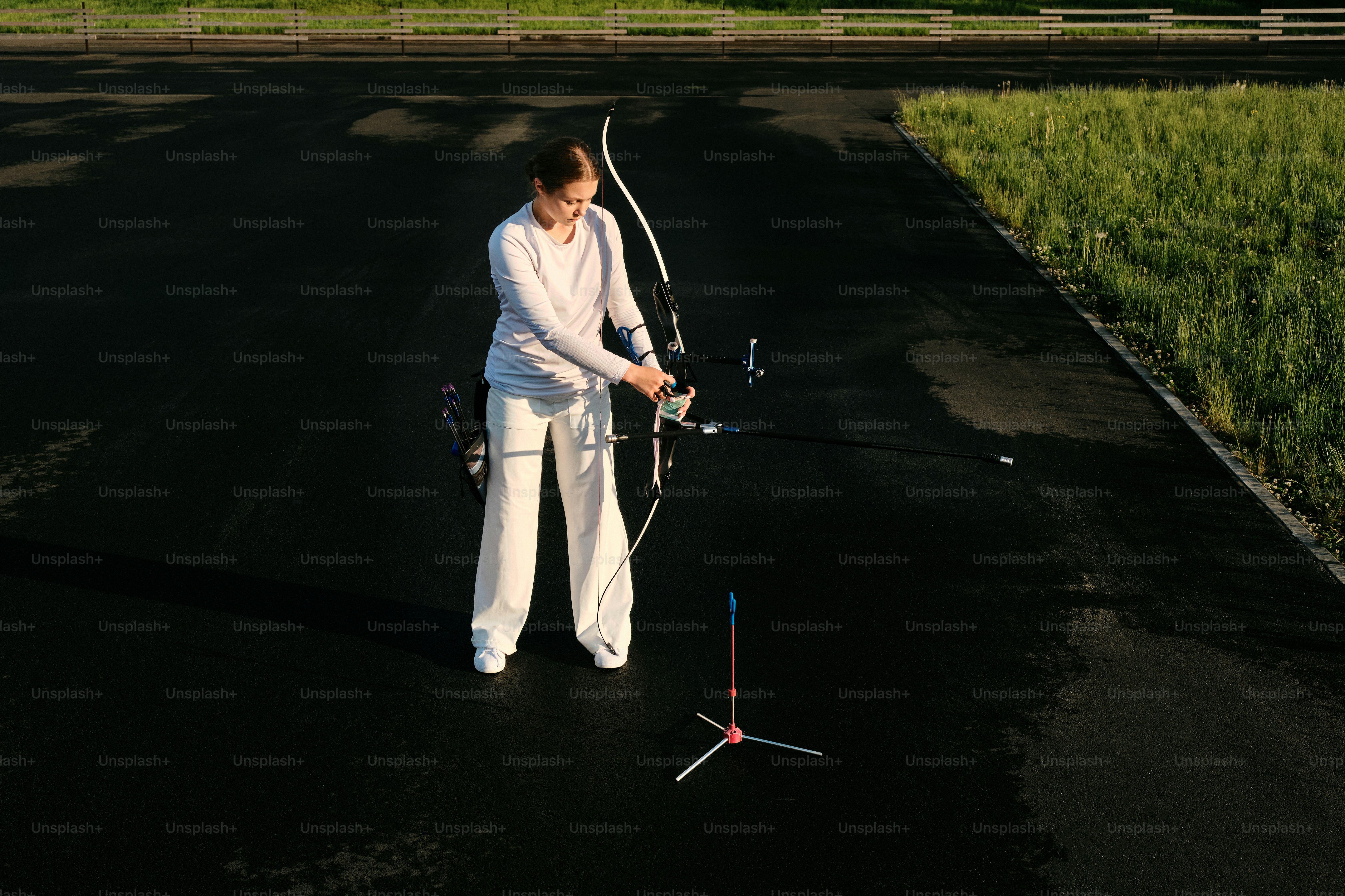 흰 옷을 입은 여자가 활과 화살을 들고 있다