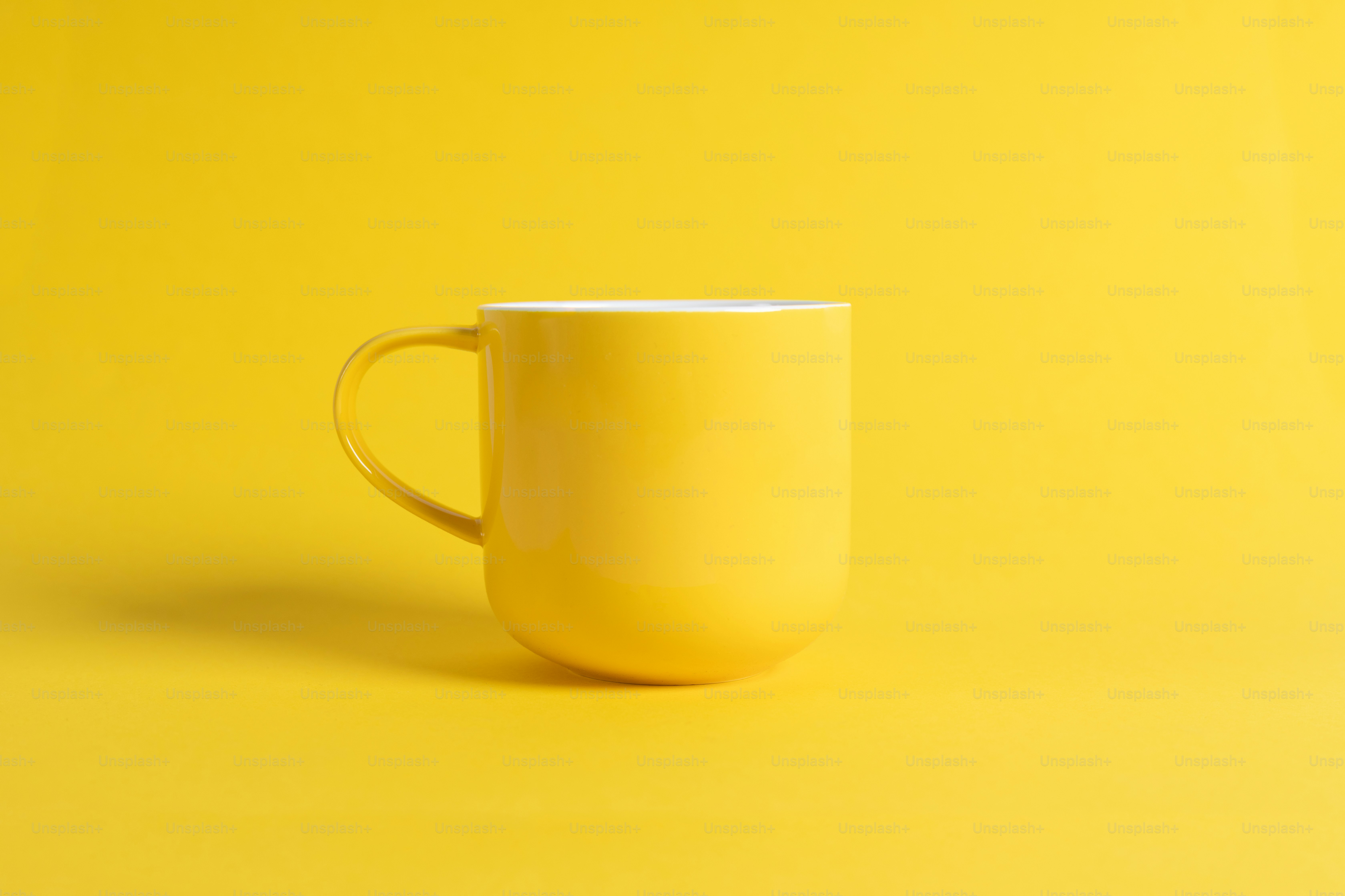 Eine gelbe Kaffeetasse auf gelbem Hintergrund