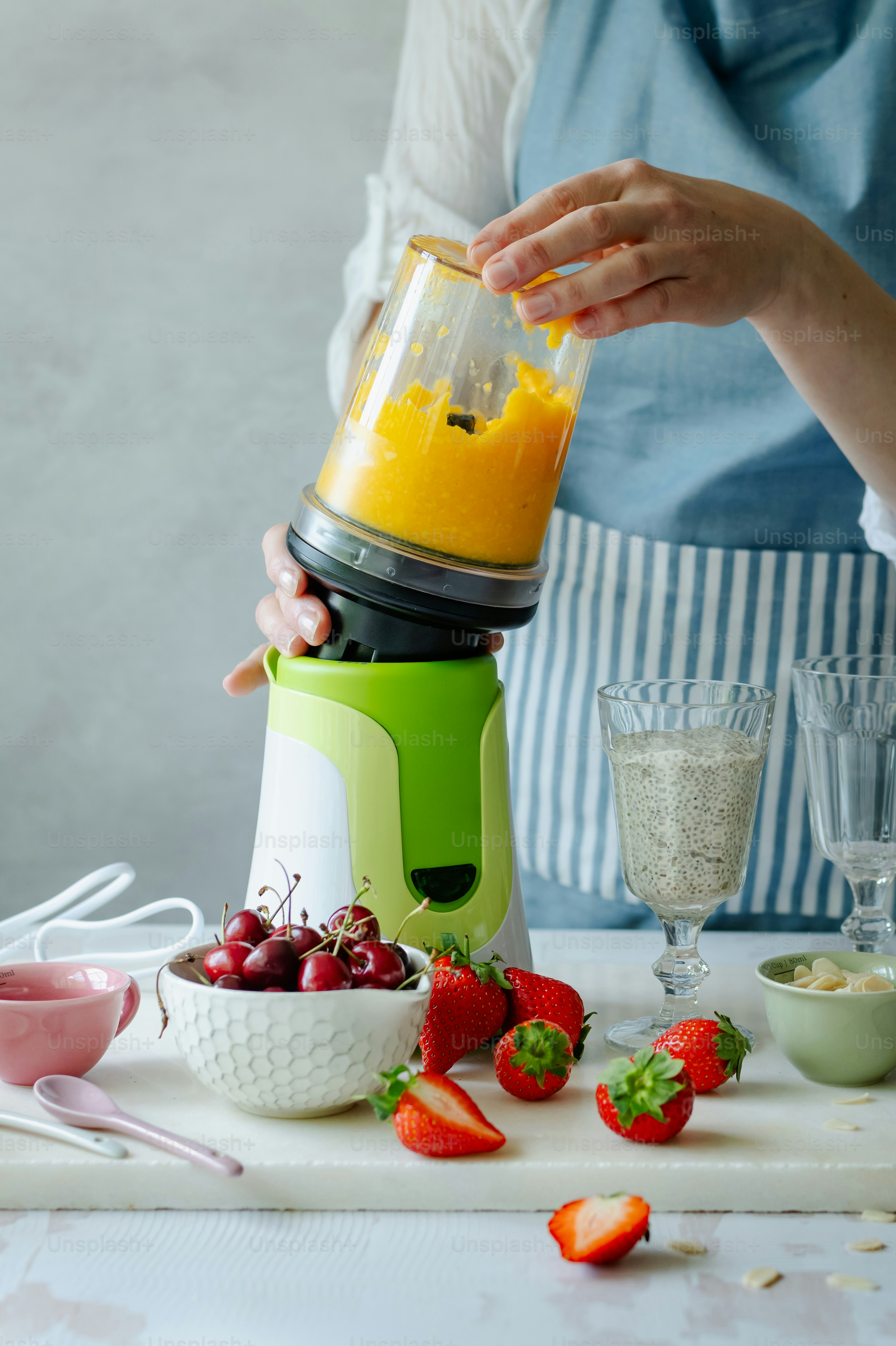Seorang wanita sedang membuat smoothie dalam blender