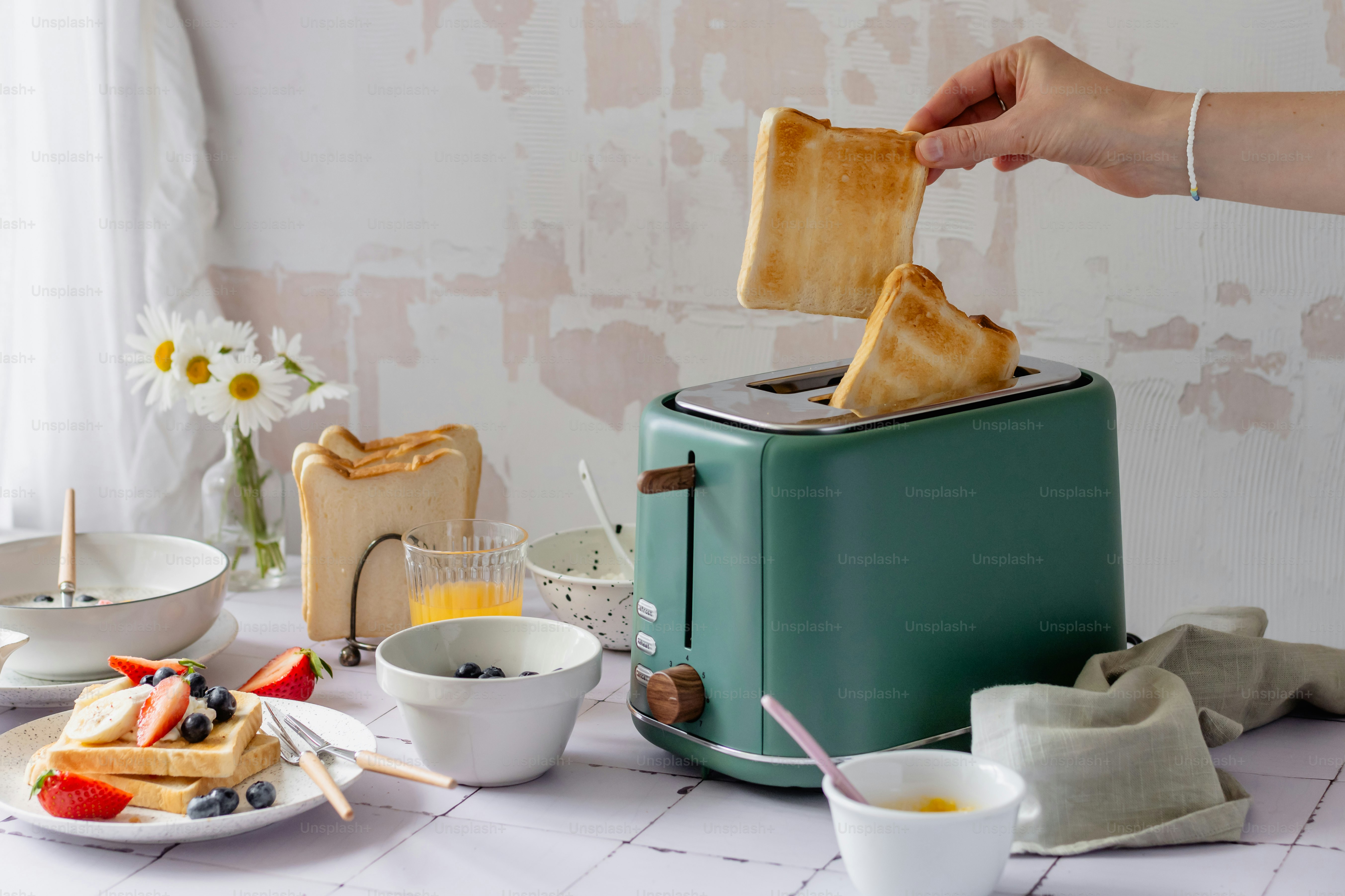 A person is putting toast into a toaster