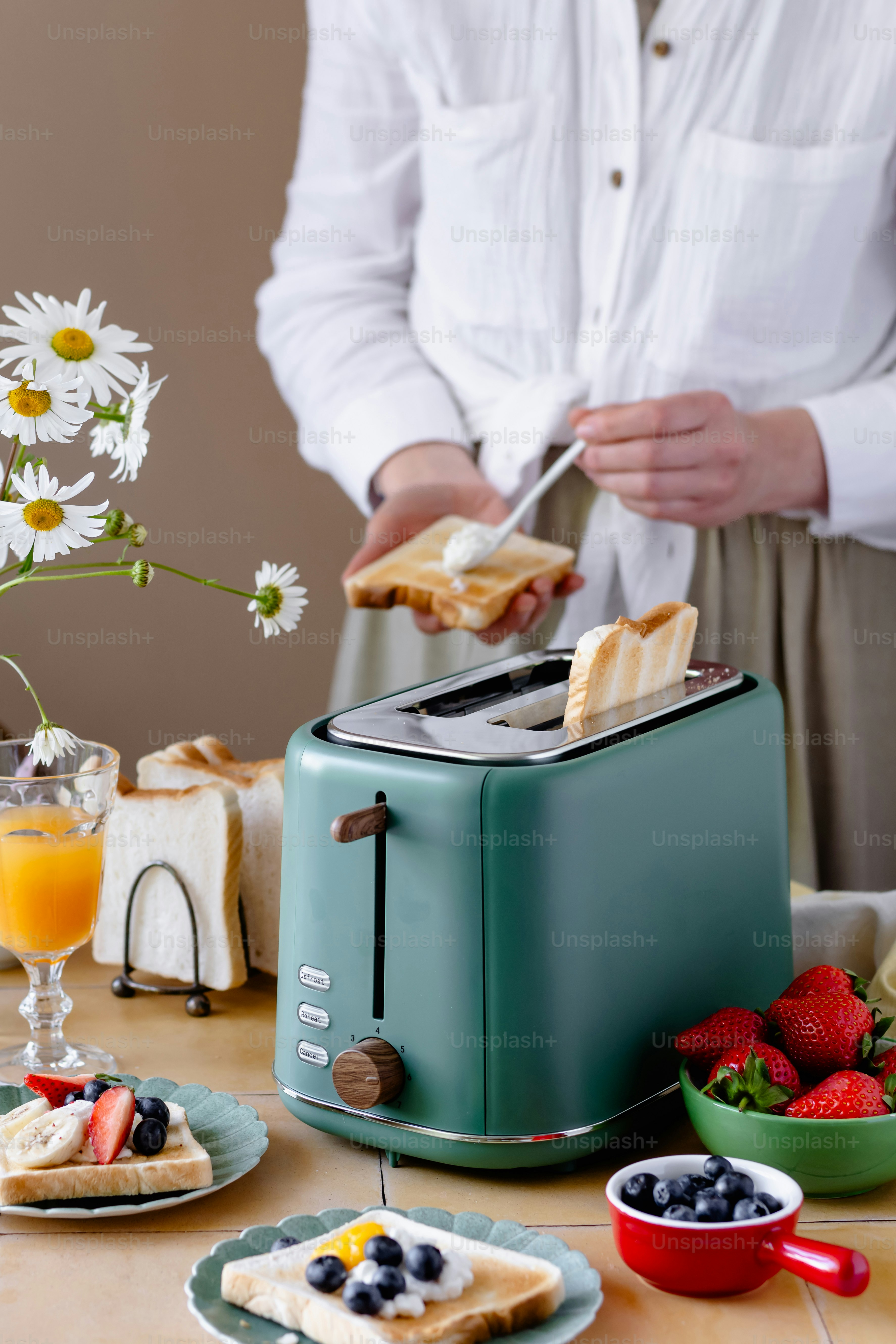 A woman is making a toaster on a table
