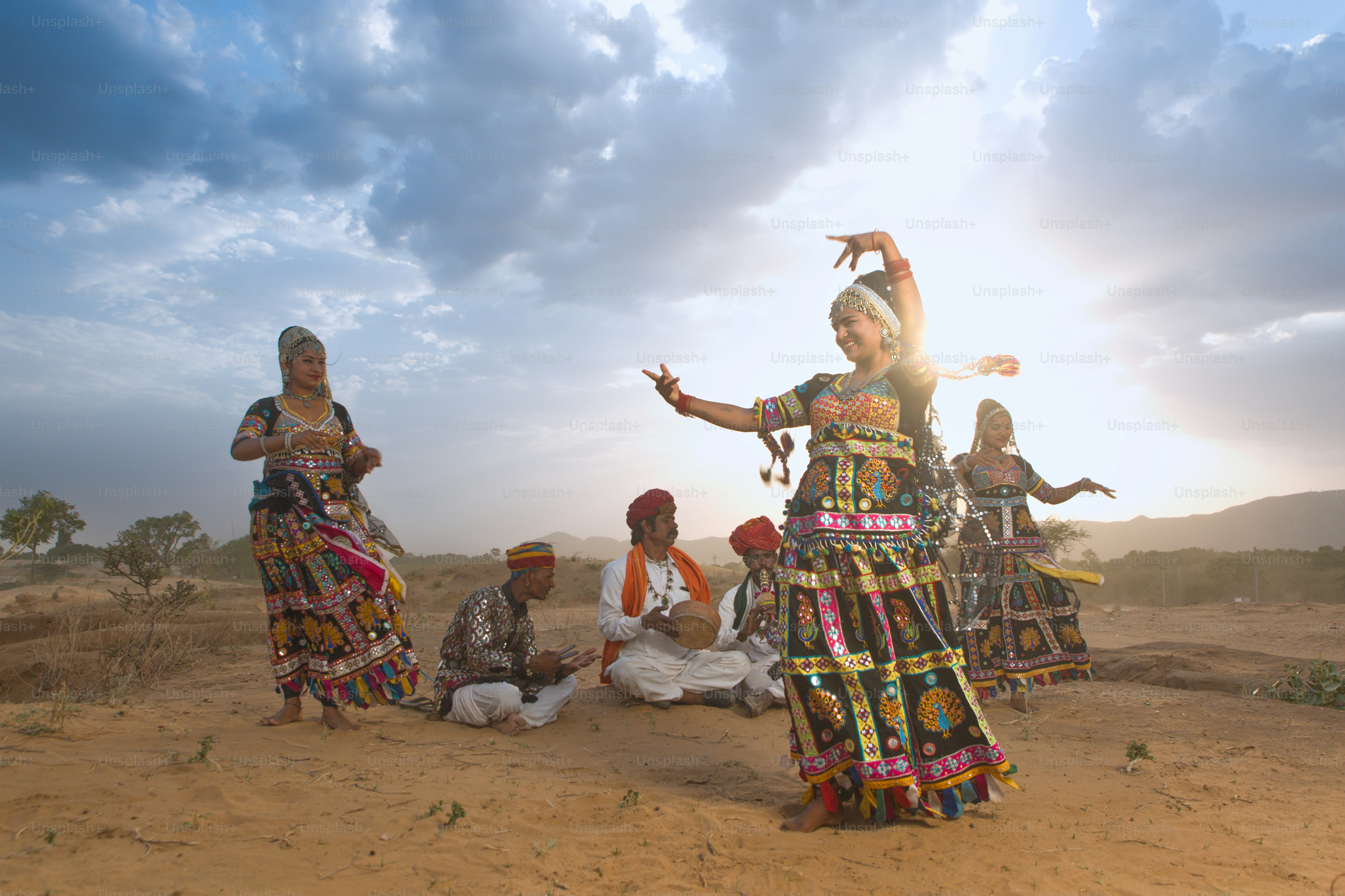 A group of people standing on top of a dirt field
