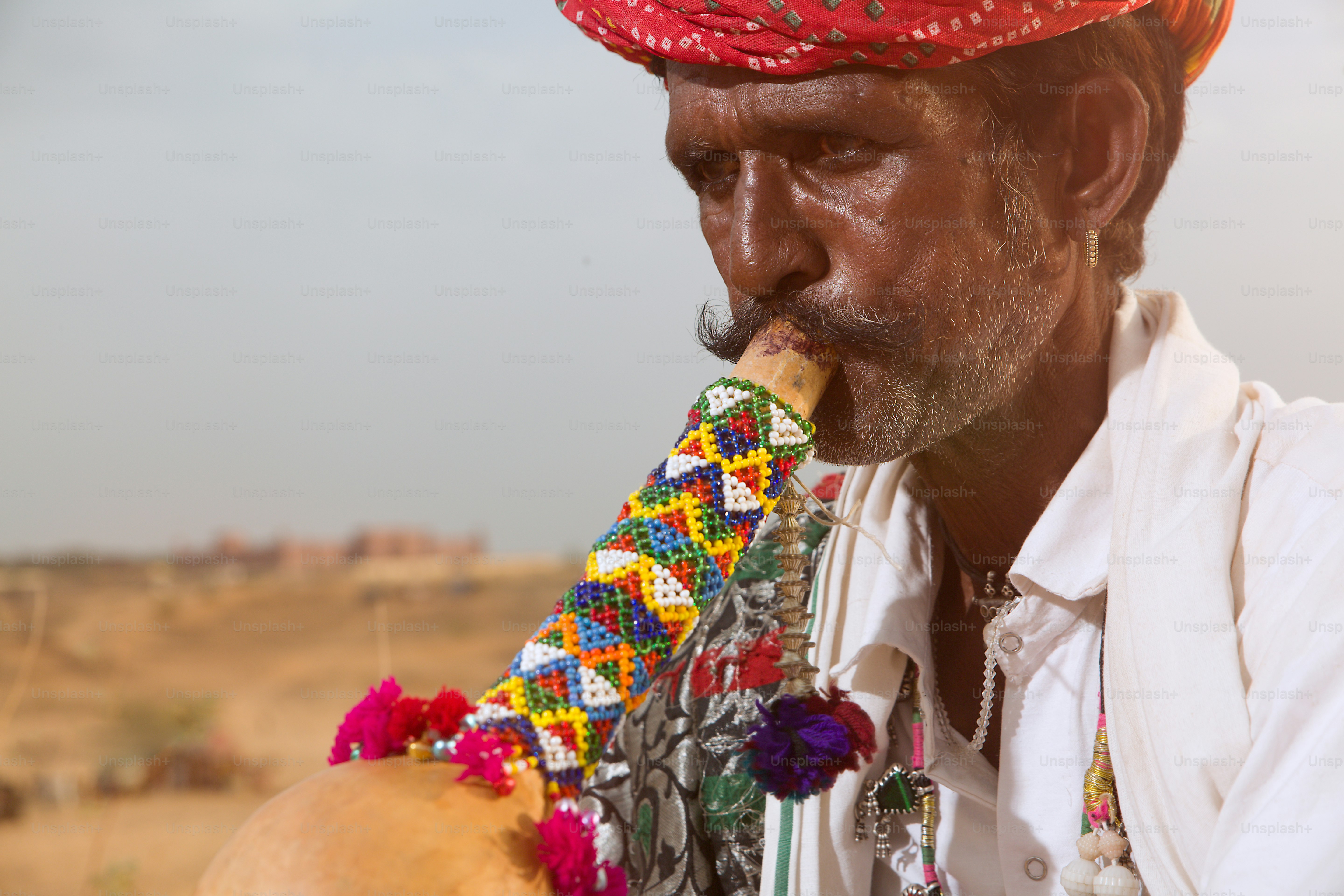 A man in a red turban smoking a pipe