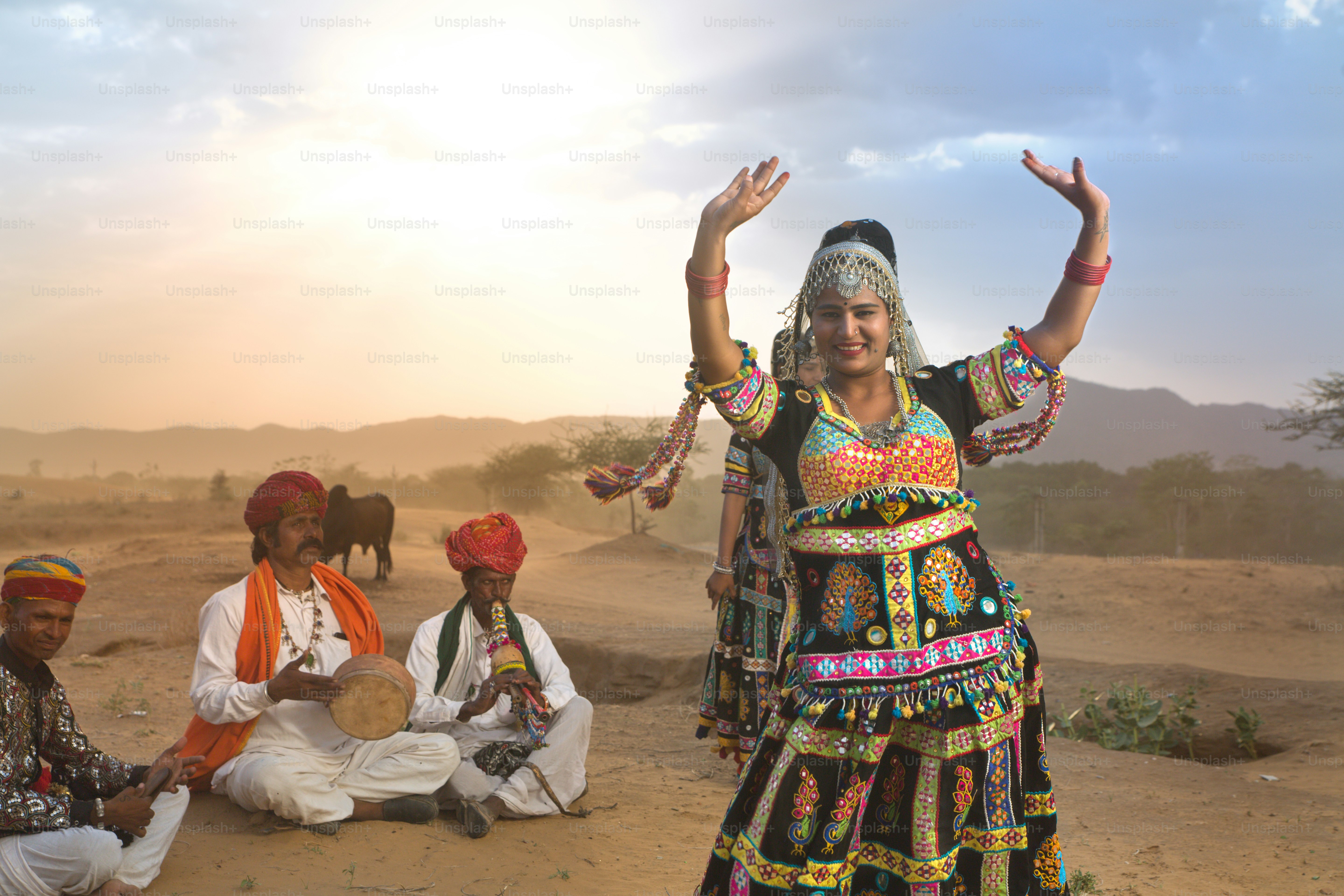 Uma mulher em um vestido colorido dançando no deserto