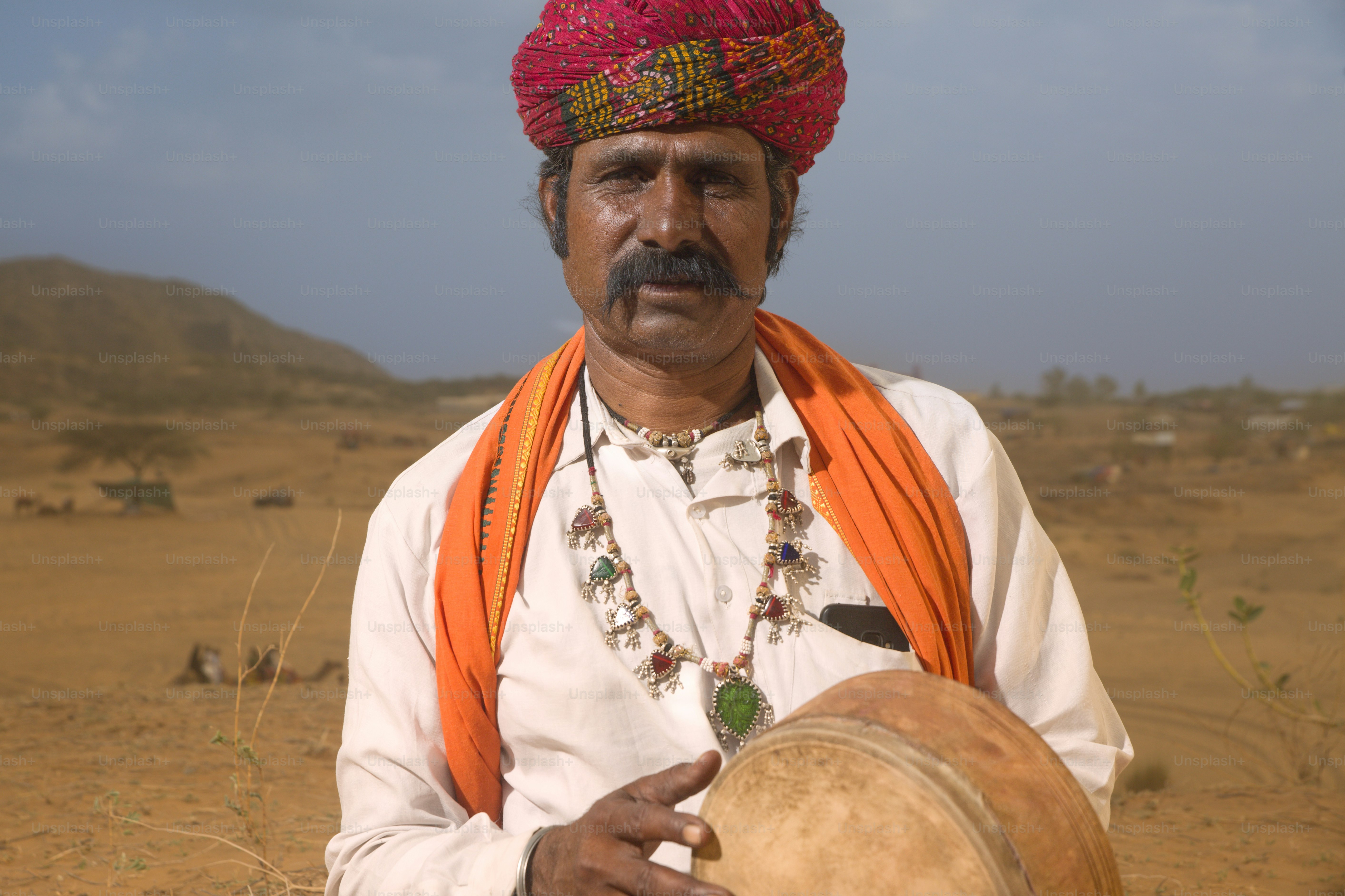 A man in a turban holding a drum