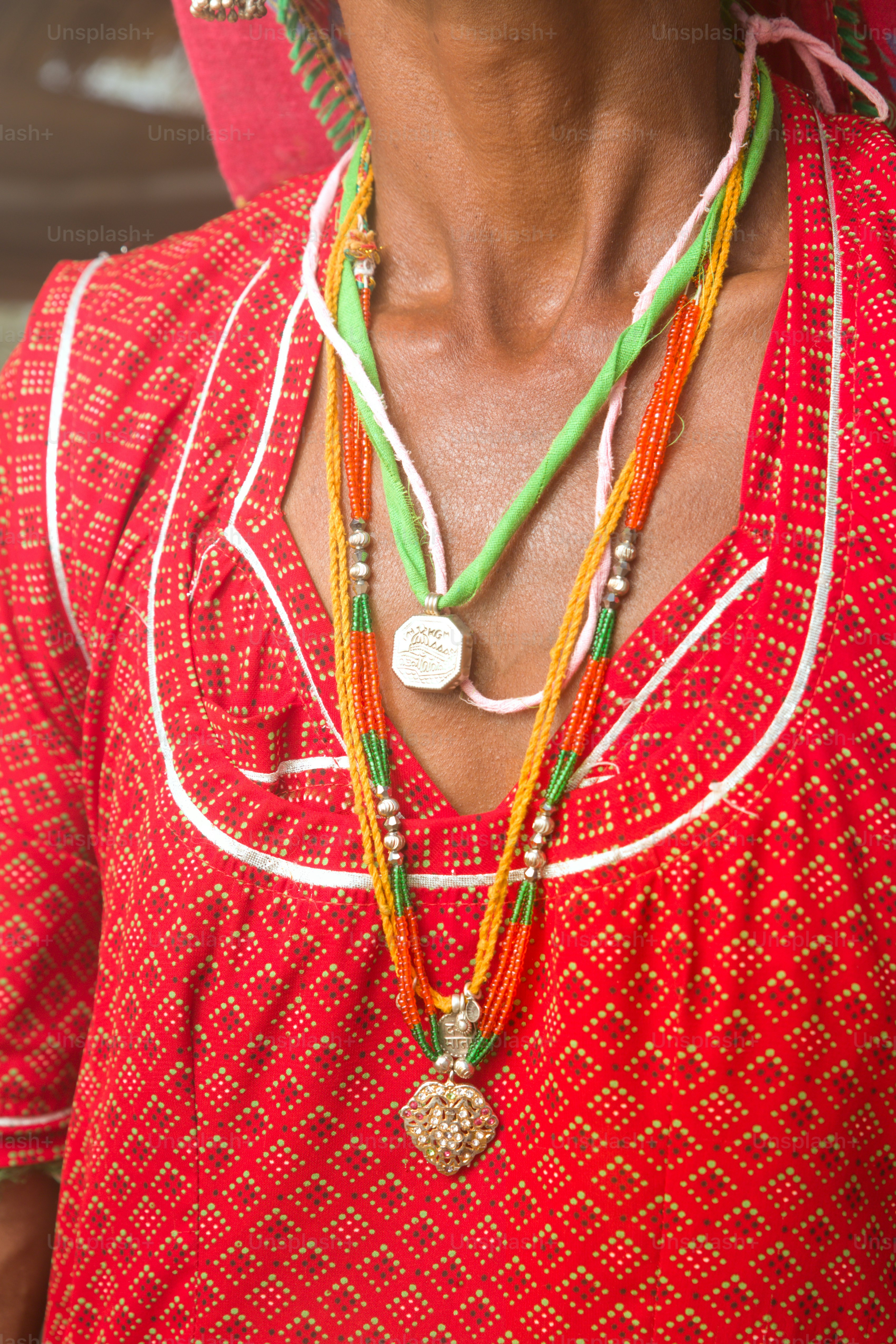 A woman wearing a red shirt and a necklace