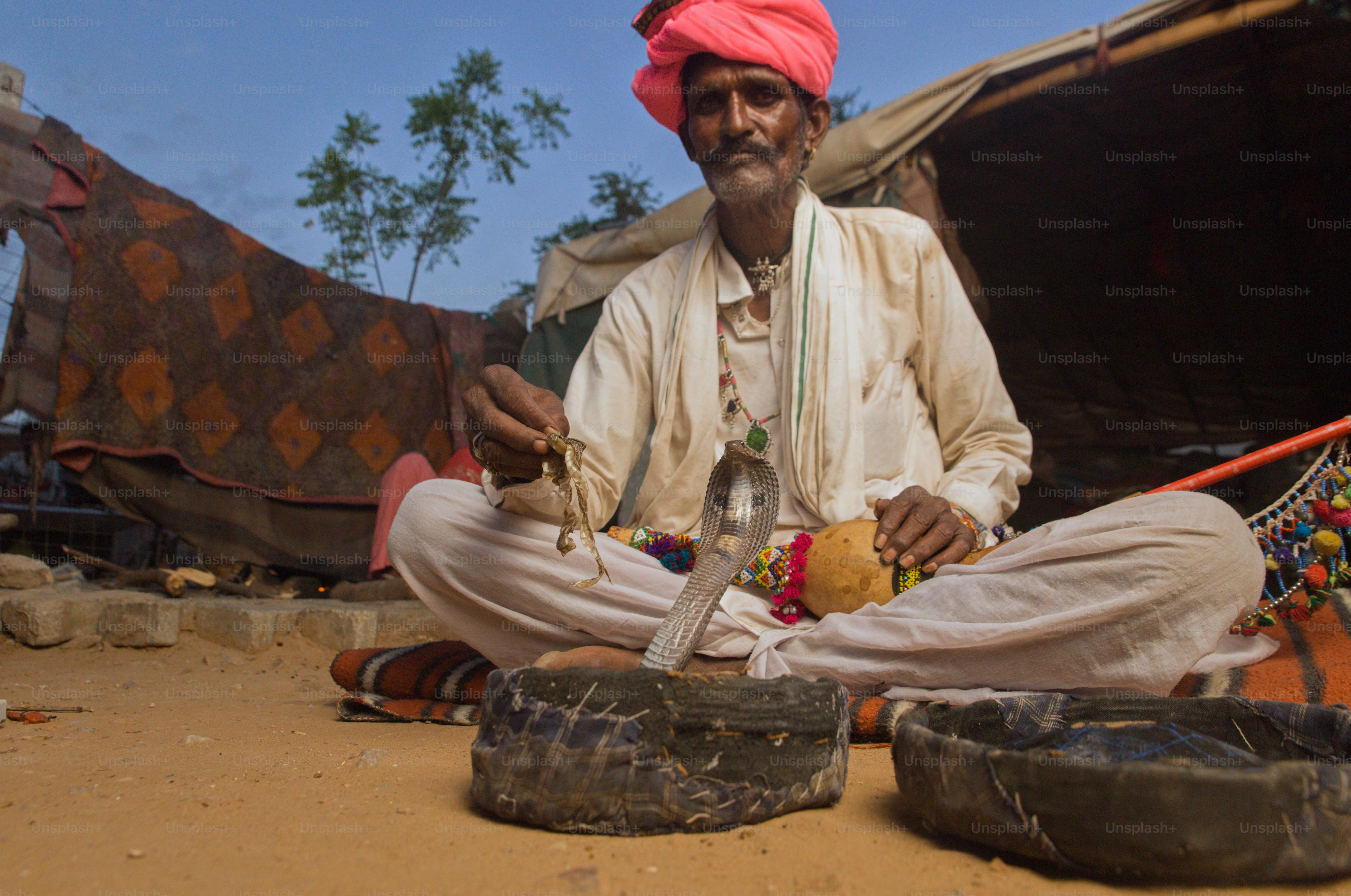 Un homme assis par terre devant une tente