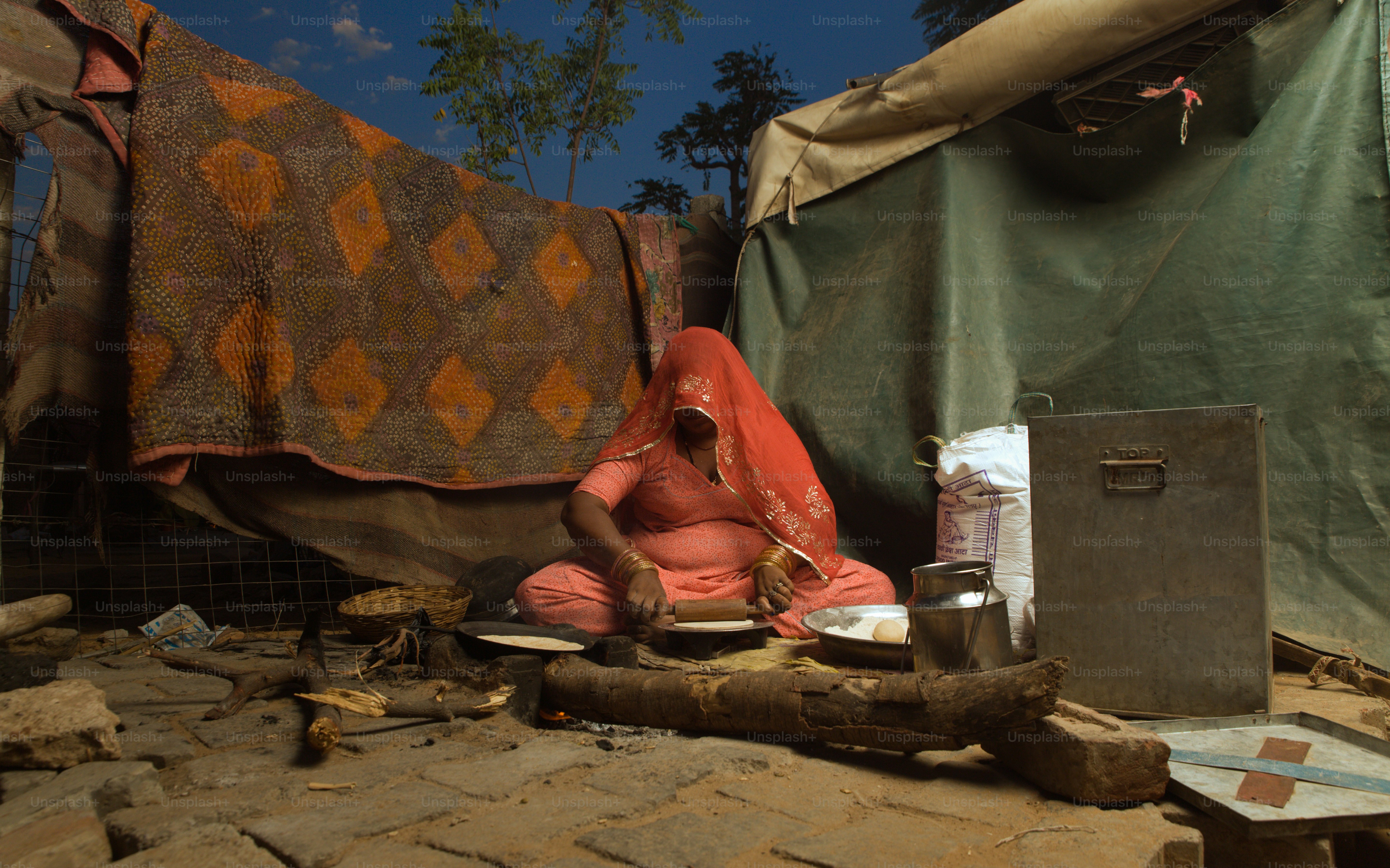 A person sitting on the ground in front of a tent