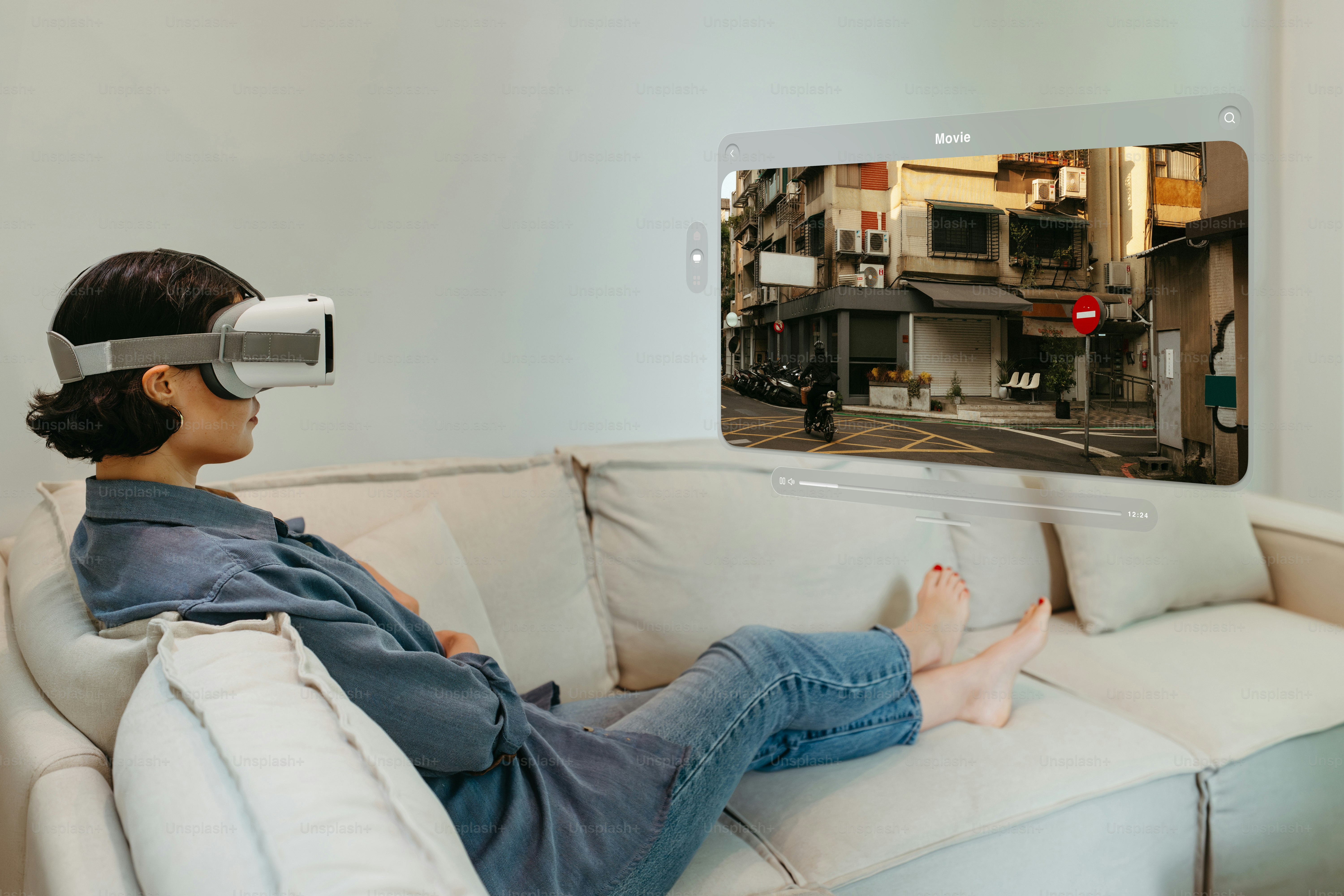 A person sitting on a couch with a video game on the wall