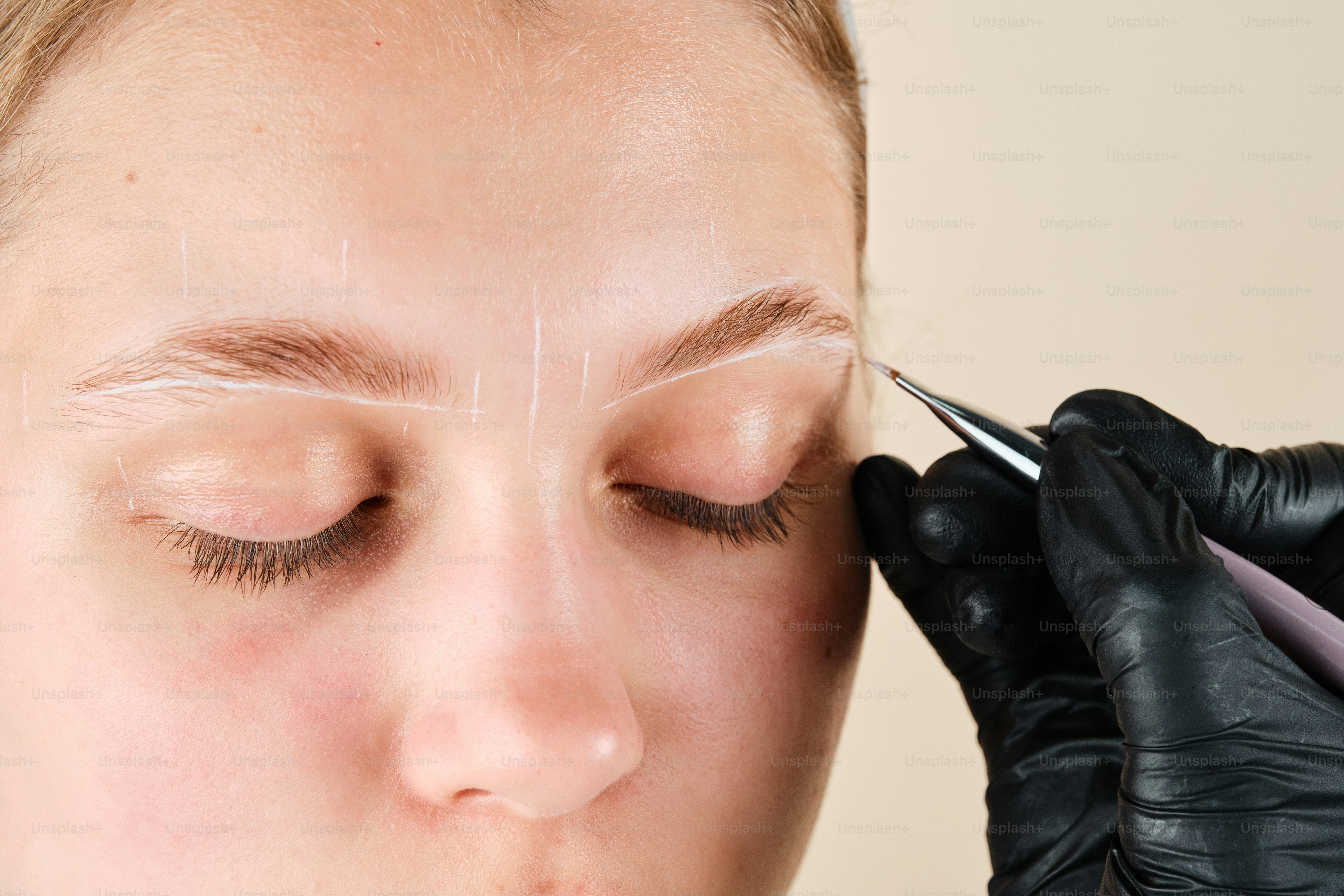 A woman getting her eyebrows done with a pair of scissors