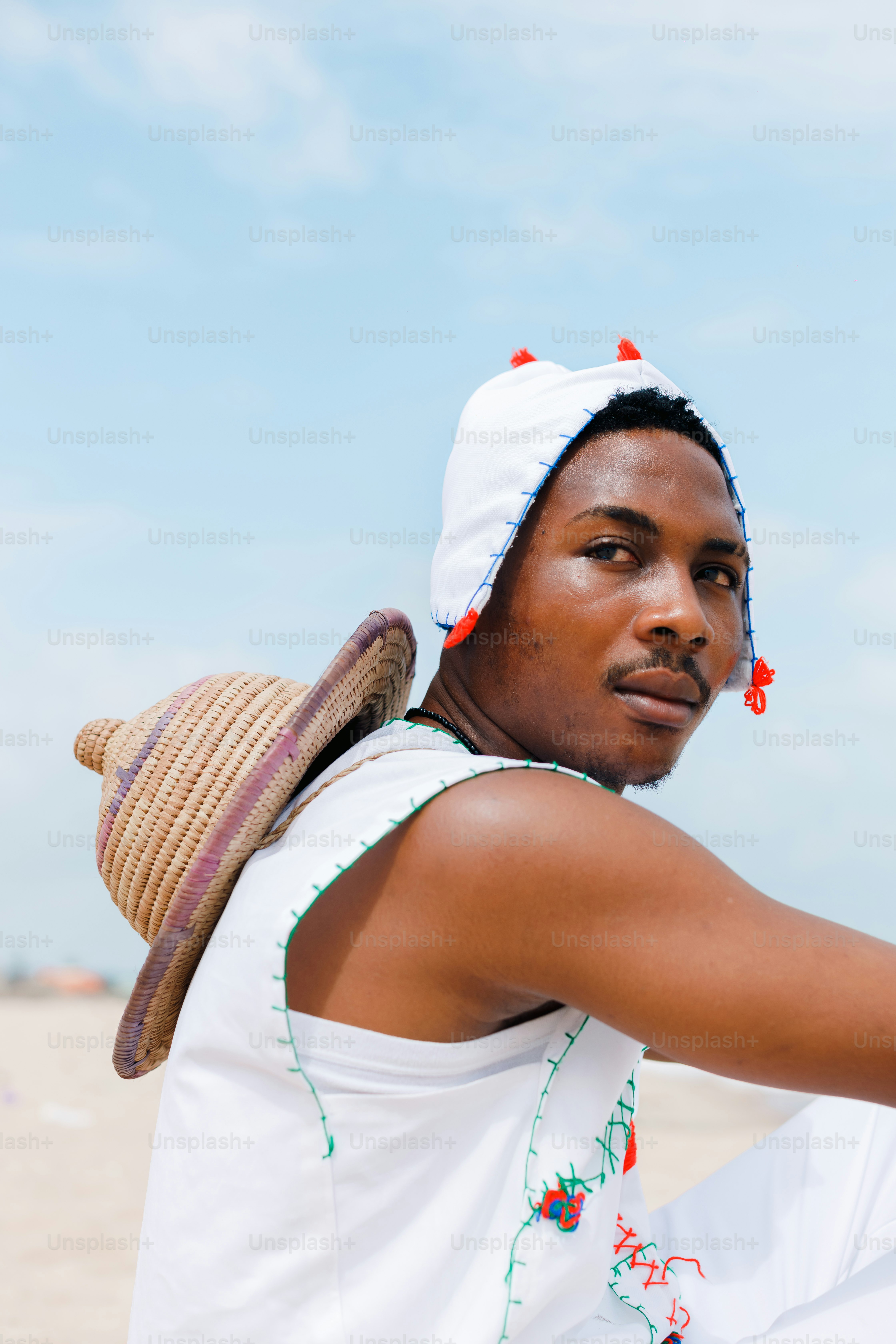 A man sitting on a beach holding a frisbee