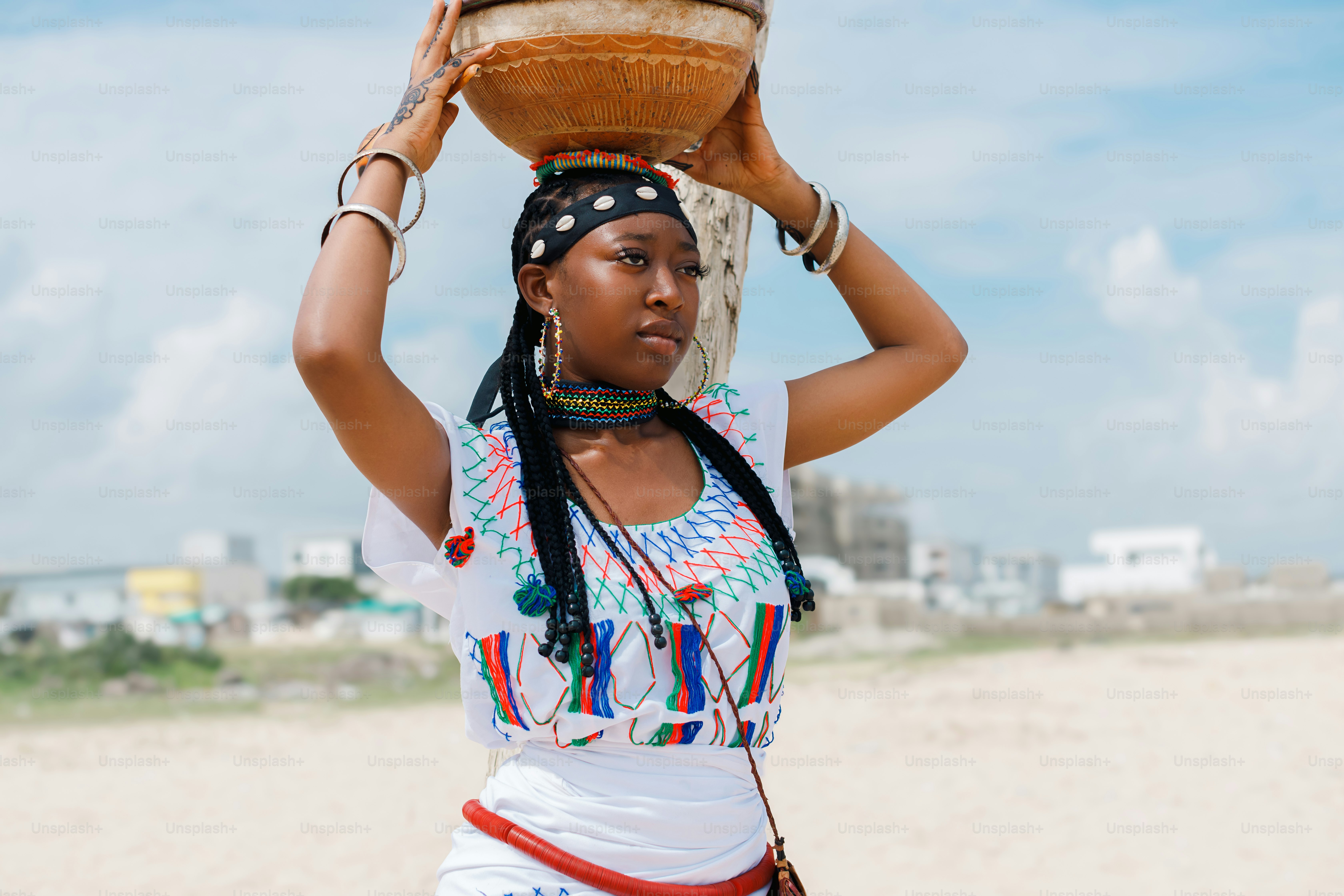A woman carrying a basket on her head on the beach