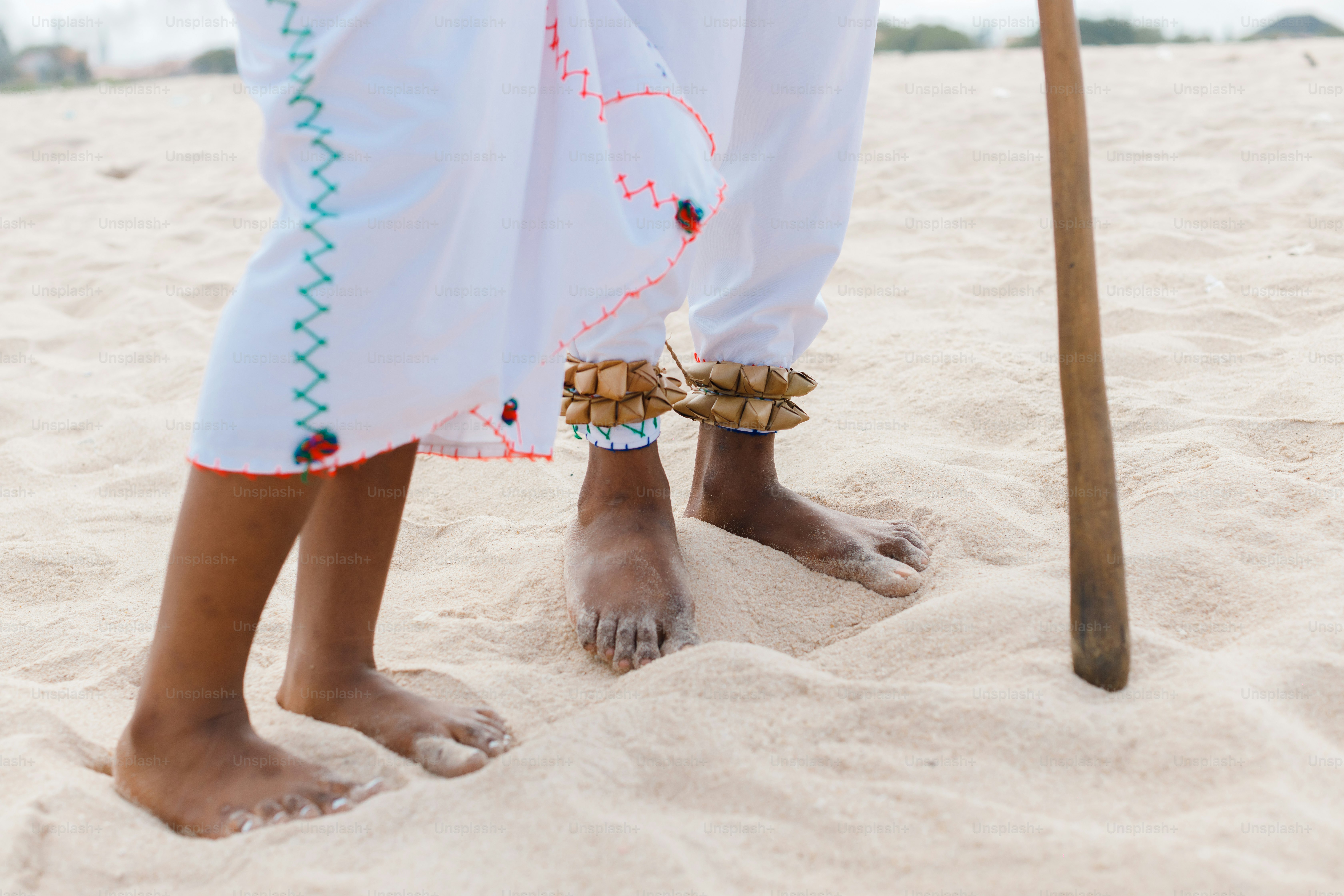 A woman standing on top of a sandy beach