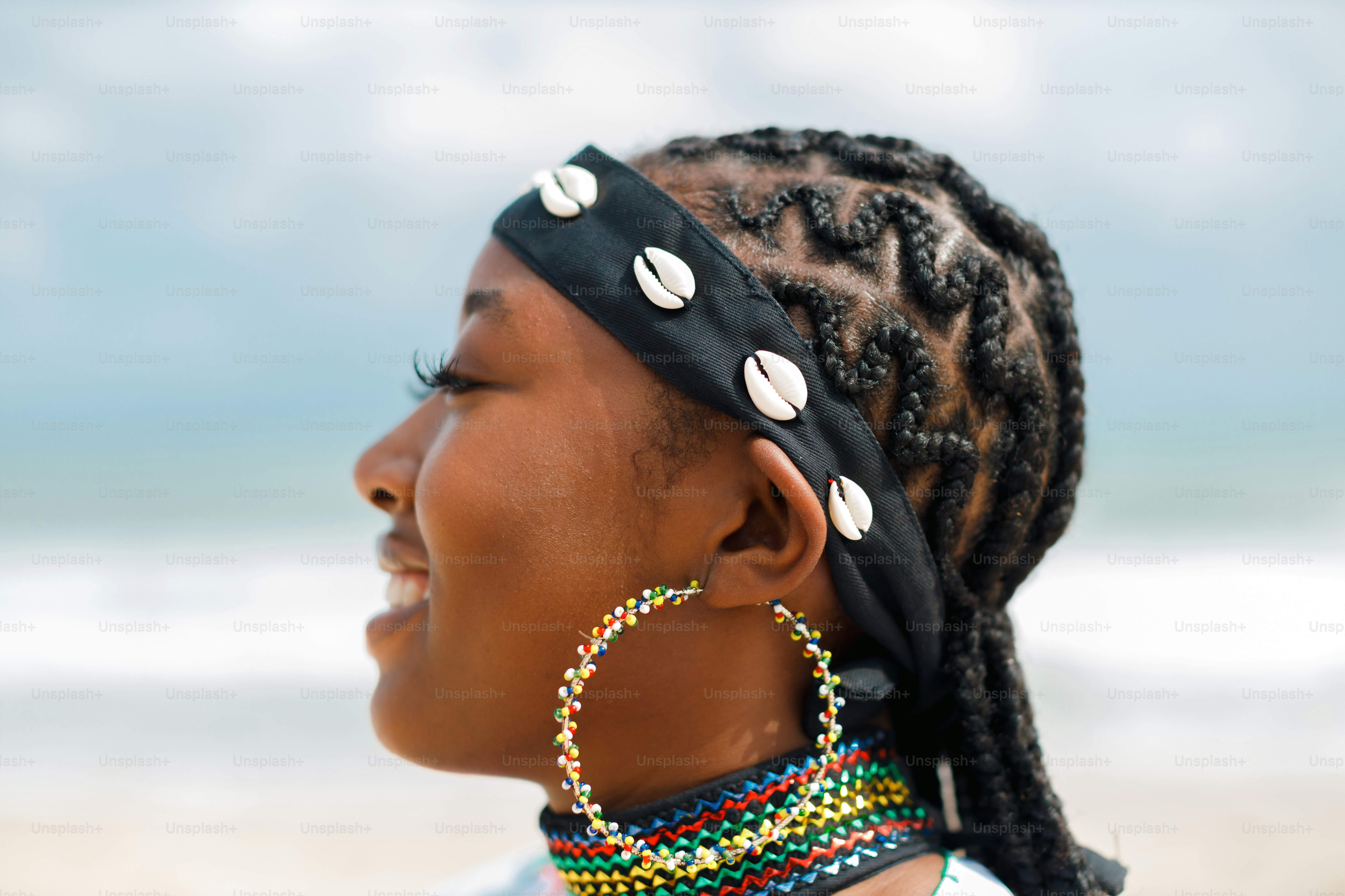 A woman standing on a beach with a pair of earrings on her head
