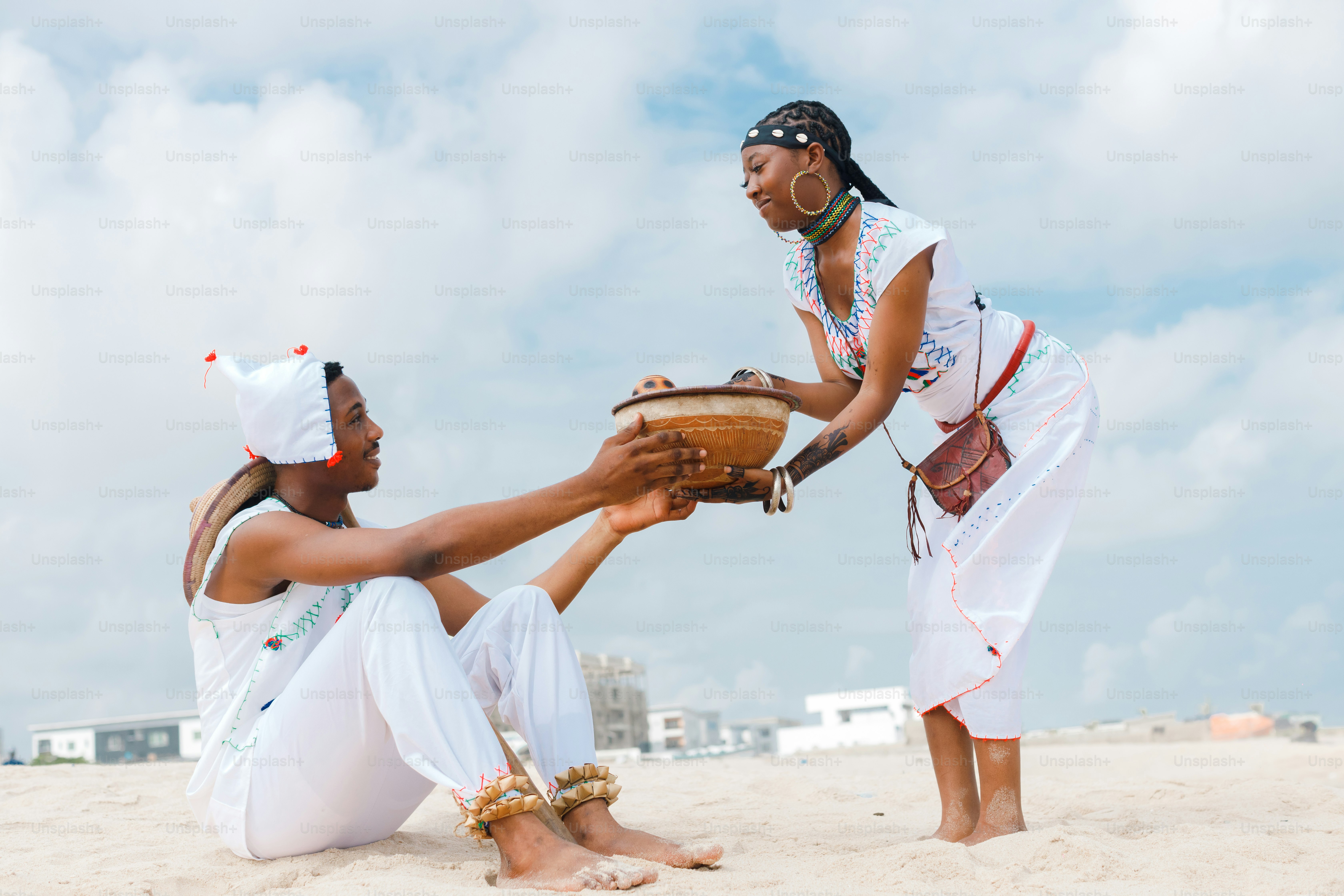 Un par de mujeres sentadas en la cima de una playa de arena