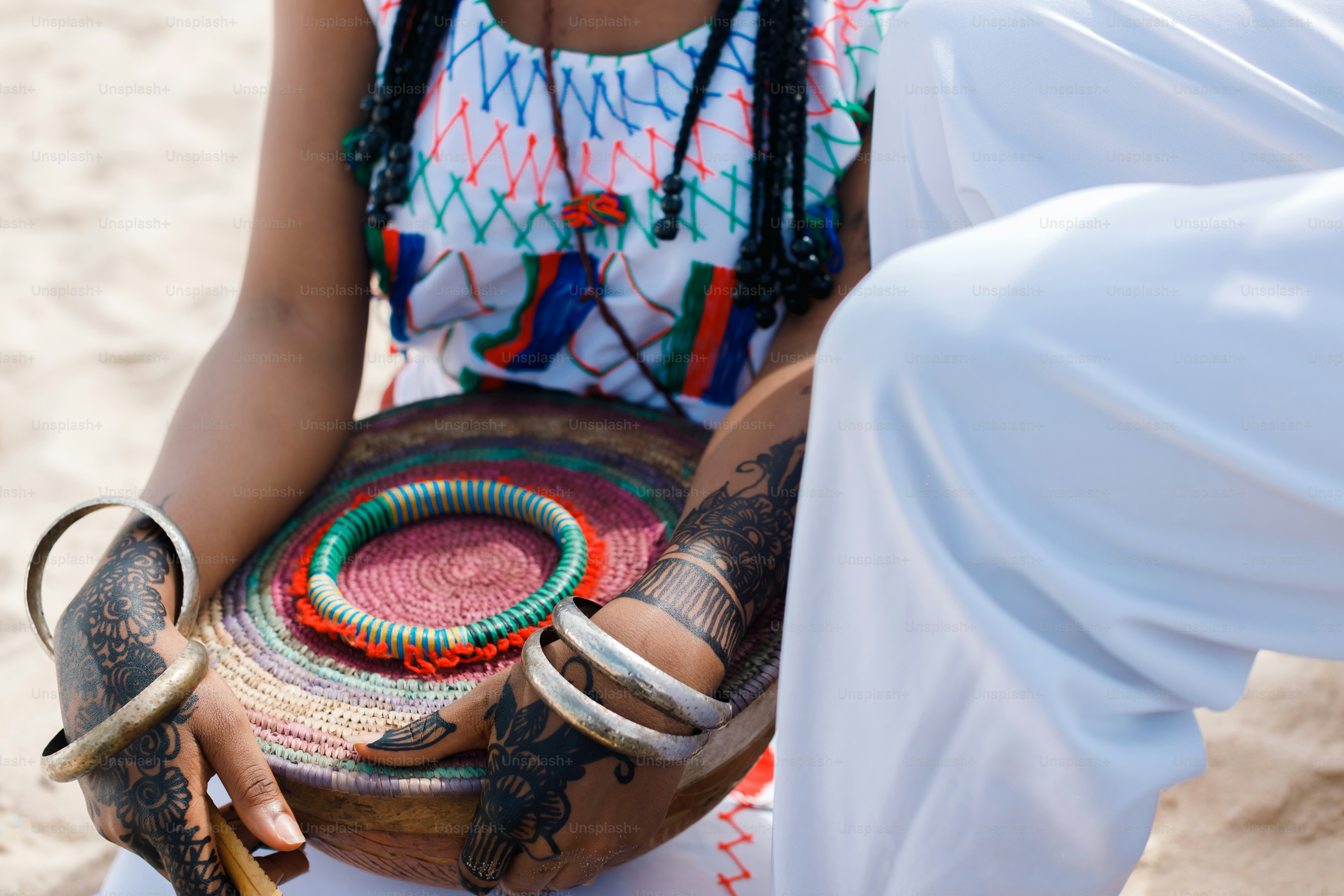 A woman sitting on a beach holding a tray